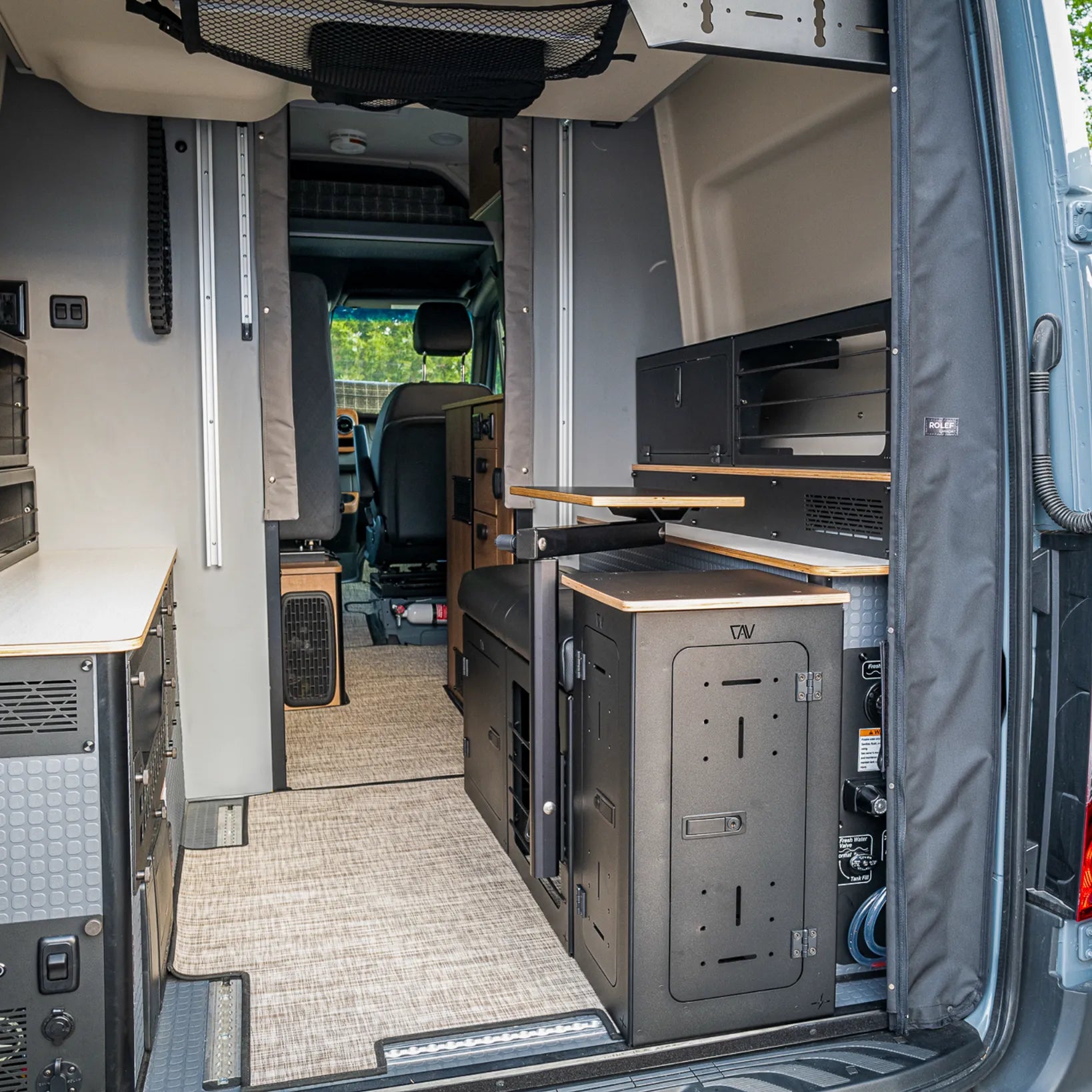 Van interior featuring Bed Risers Pro set with bungee configuration and lower storage box installed in Winnebago Revel.