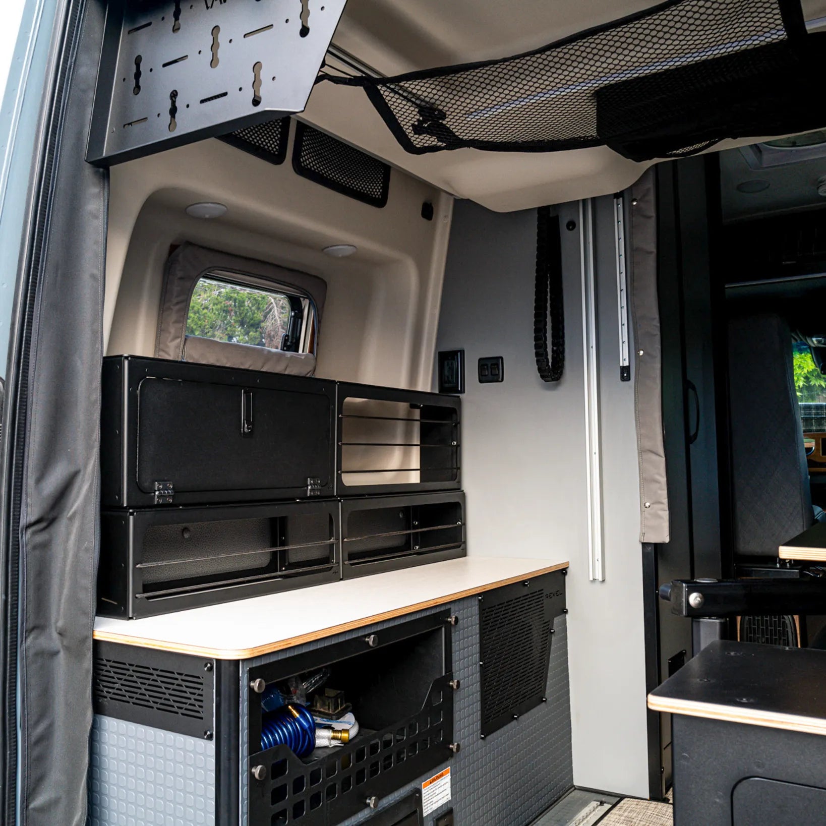 Pro Series bungee bed risers and lower storage box installed in rear of Winnebago Revel van.