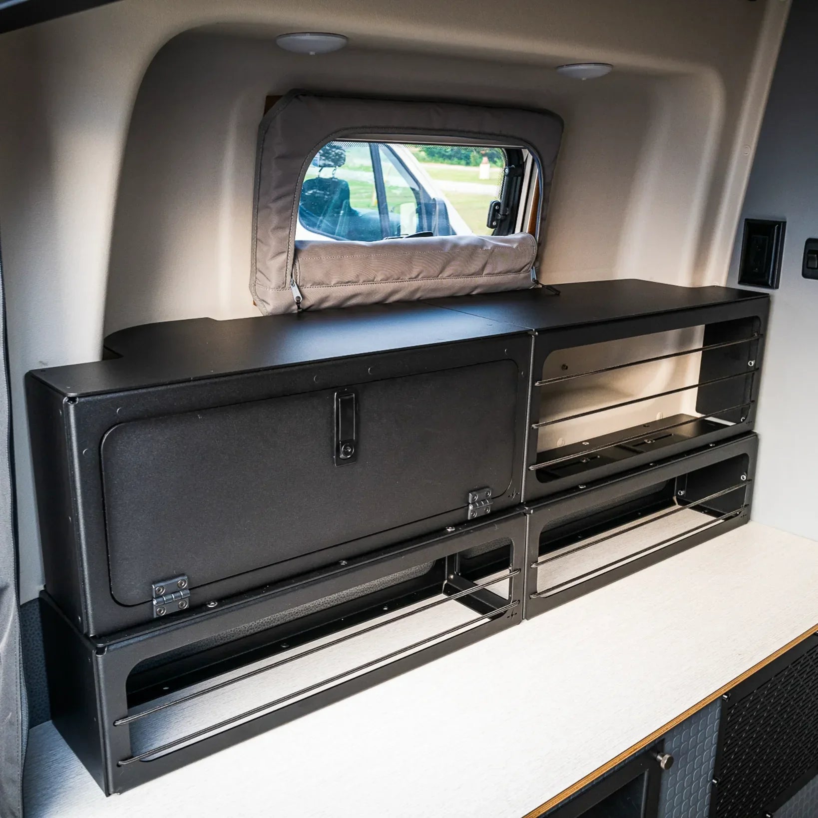 Pro Series bed risers with lower storage box installed in rear van interior of Winnebago Revel 25.