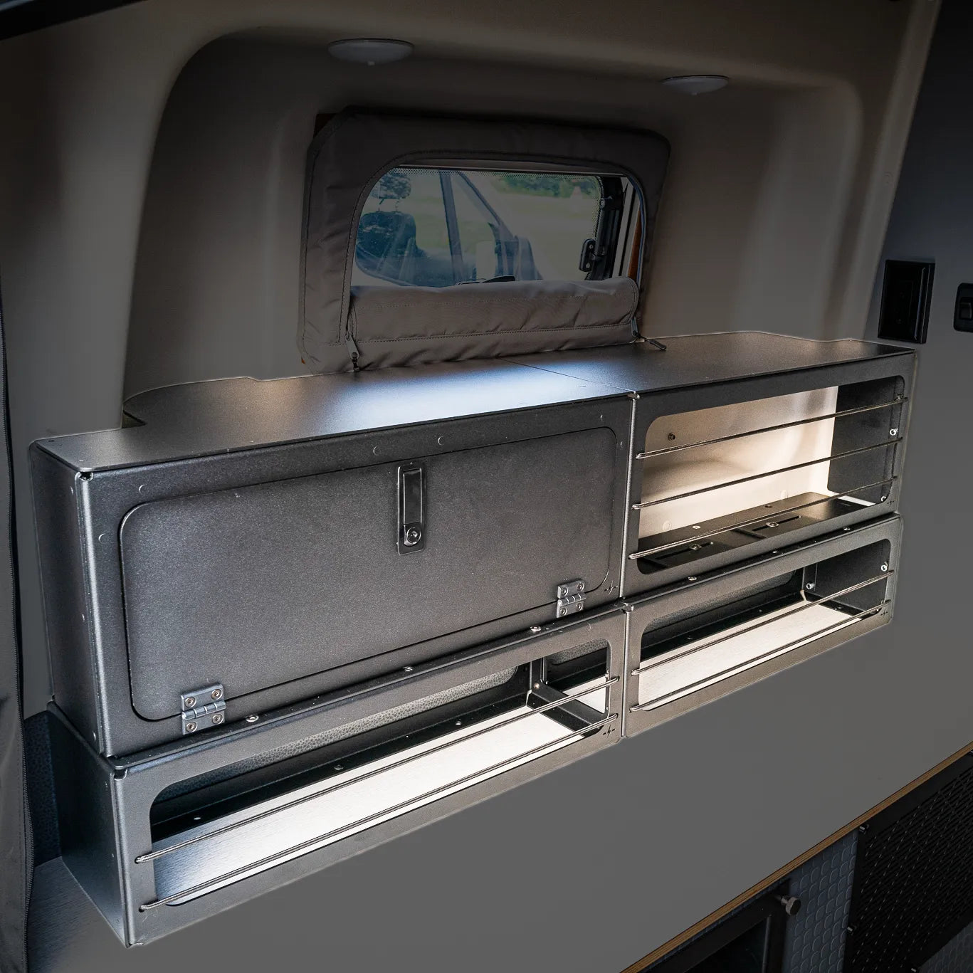 Lower storage box installed in rear van wall above bed area in a Winnebago Revel.