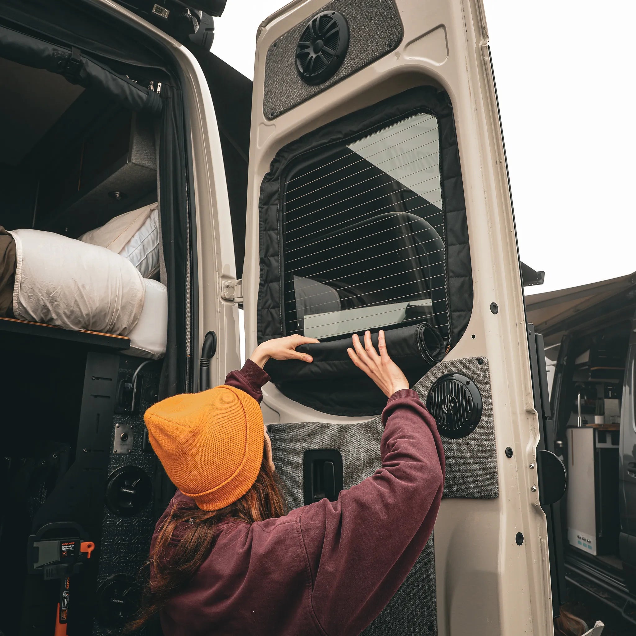 Person installing Clima-Shade on rear door window of a Sprinter van.