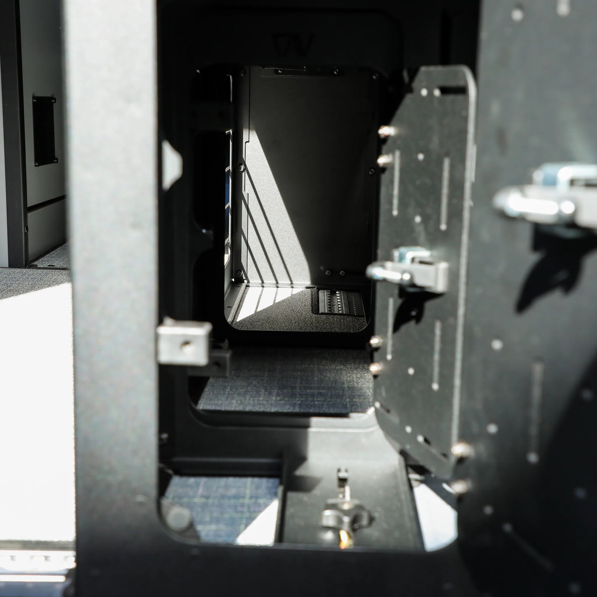 Interior view of GLSS Passenger PRO storage unit with open desk and H2O box in a 2025 Revel van.