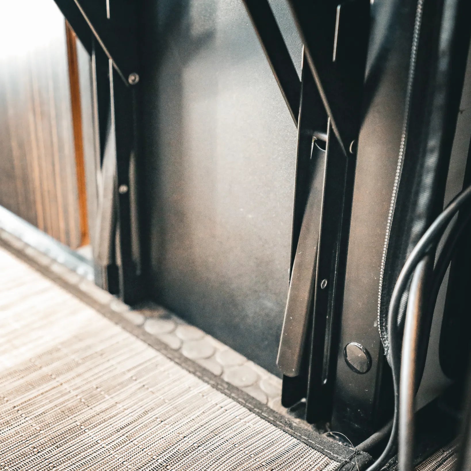 Close-up of Folding Bed Step PRO installed in a Revel van interior near the bed base.