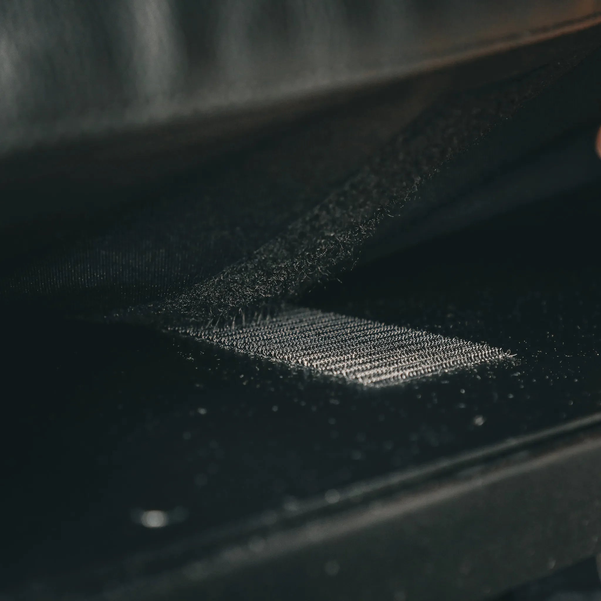 Close-up of the Bed Risers PRO bungee attachment under a bed in a Revel van.