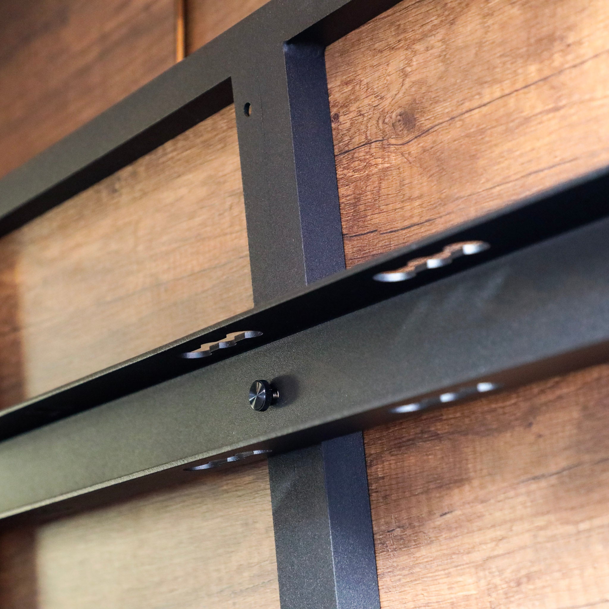 Close-up of the Legless Bed Support System 2.0 by Storyteller Overland mounted on a van wall.