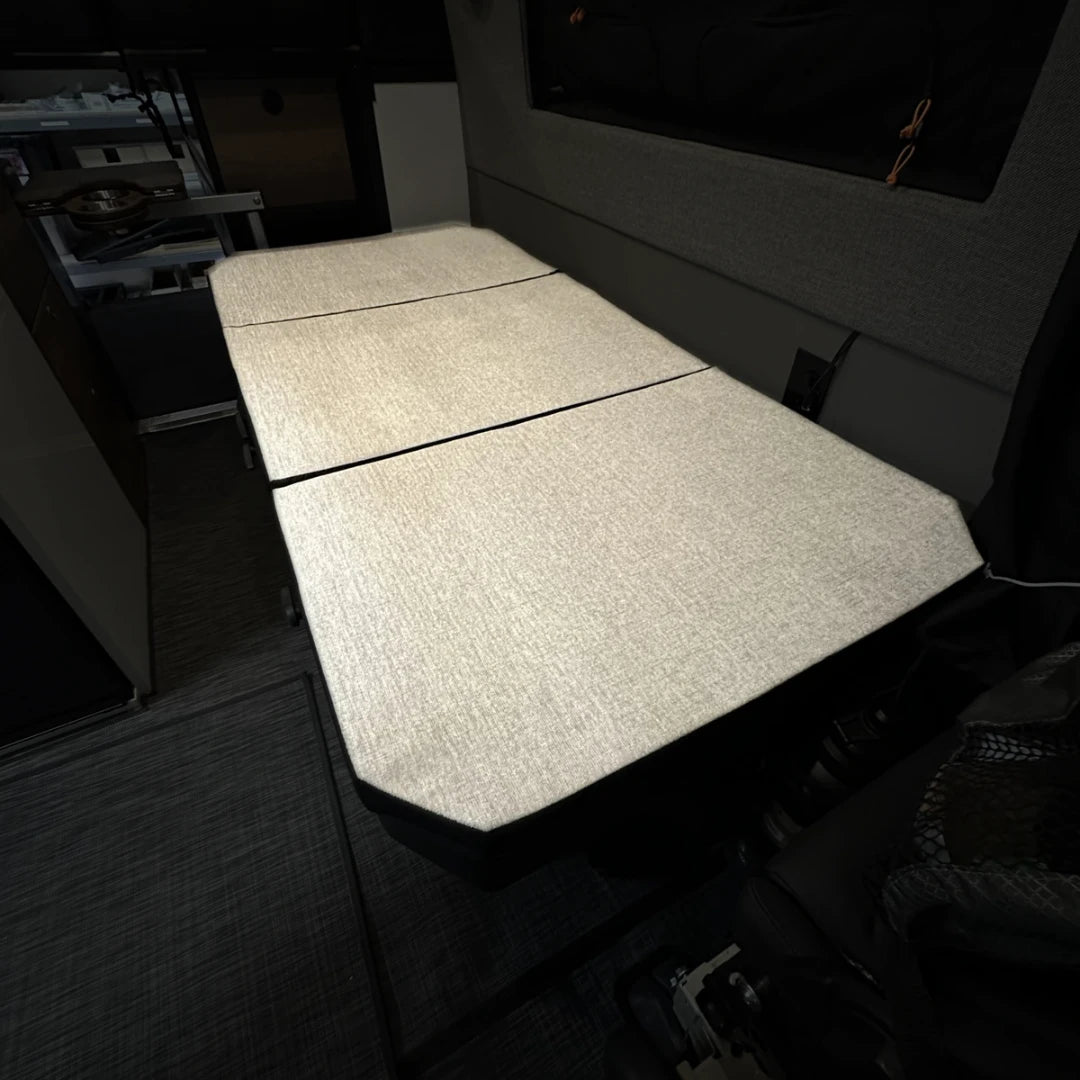 Groove Lounge Mattress Topper by Revel shown inside a Storyteller van setup for sleeping.