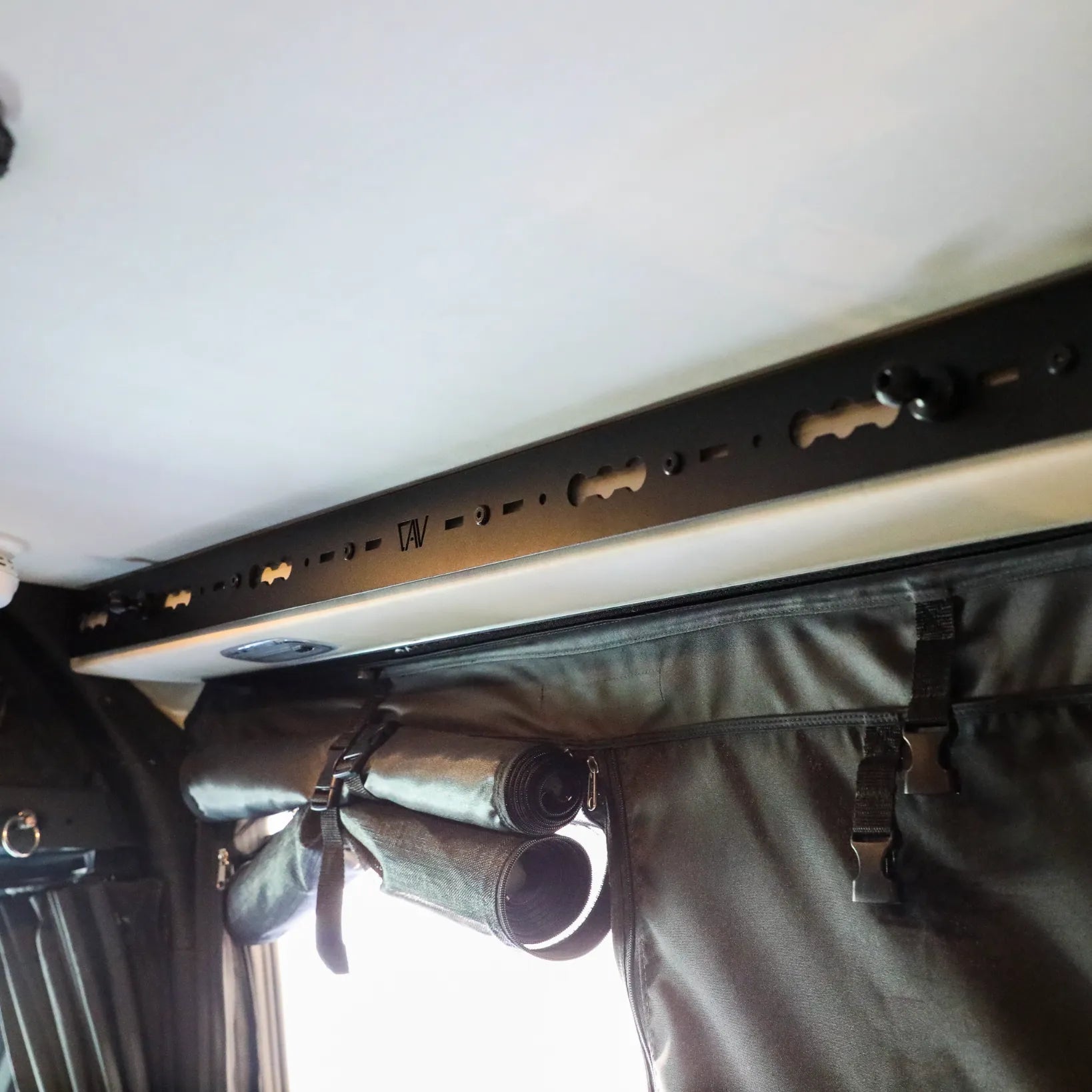 L-Track Pro installed on ceiling above sliding door in a Storyteller Overland Mode van interior.