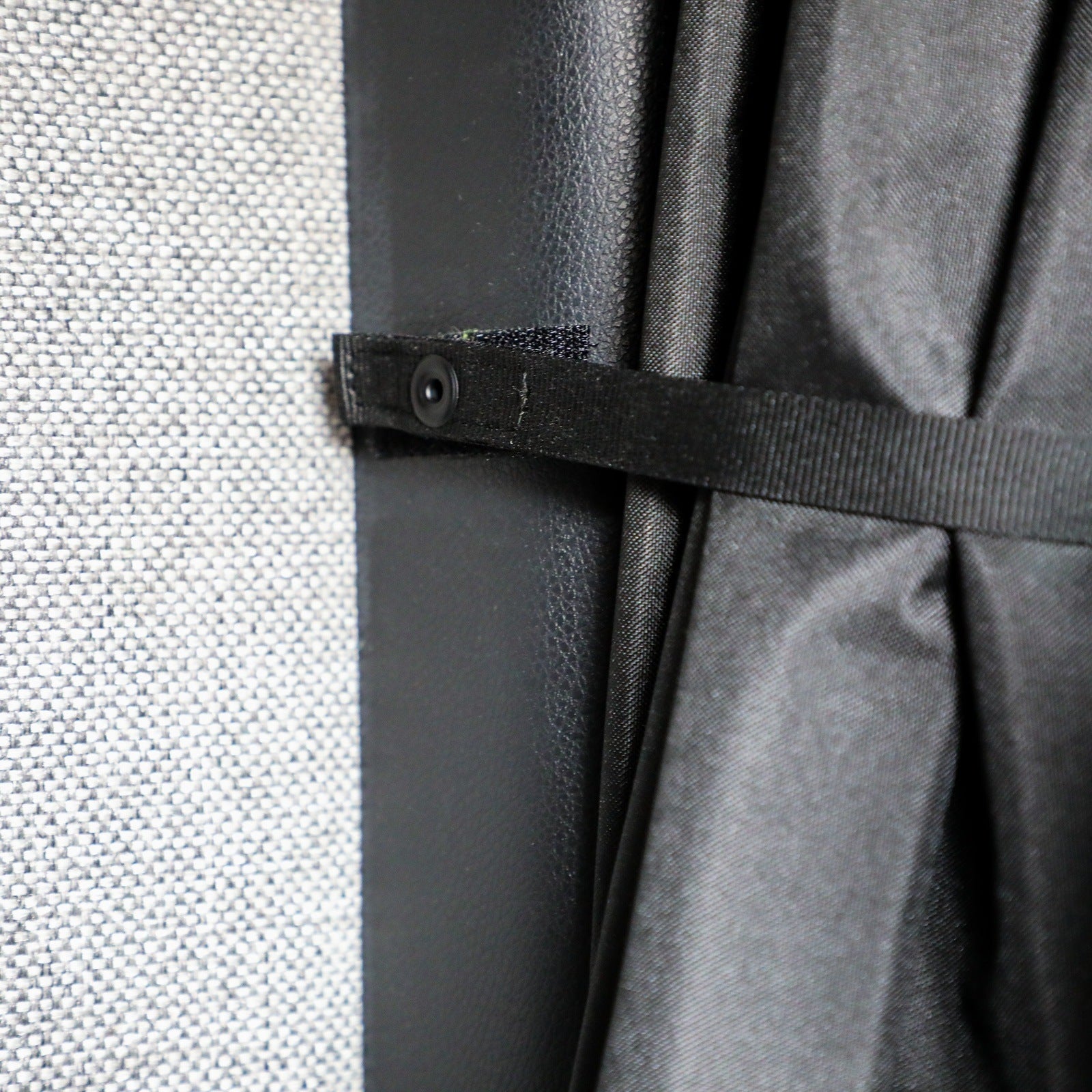 Close-up of the Ultimate CLIMA-SHADE Bundle strap secured inside a Revel van interior.