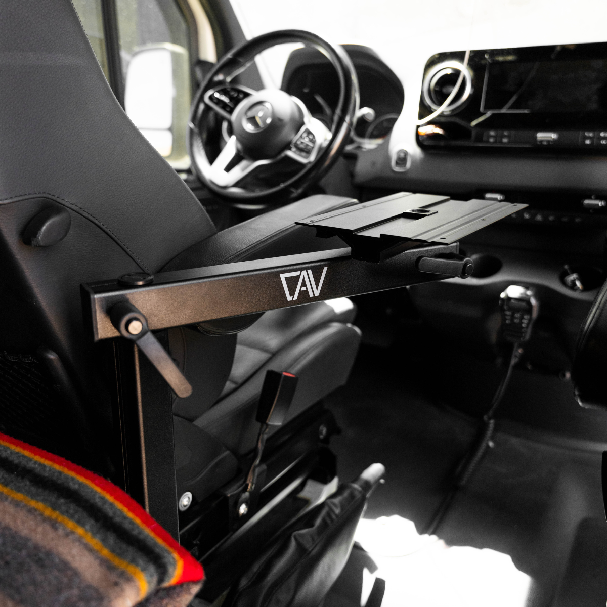 CAV Canyon Table Leg System mounted beside the drivers seat in a van interior.