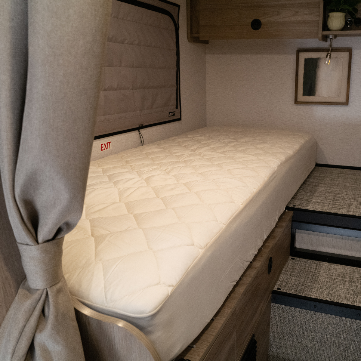 Ultra Luxe mattress in a Winnebago Ekko van with wood cabinetry and a cushioned sleeping area.