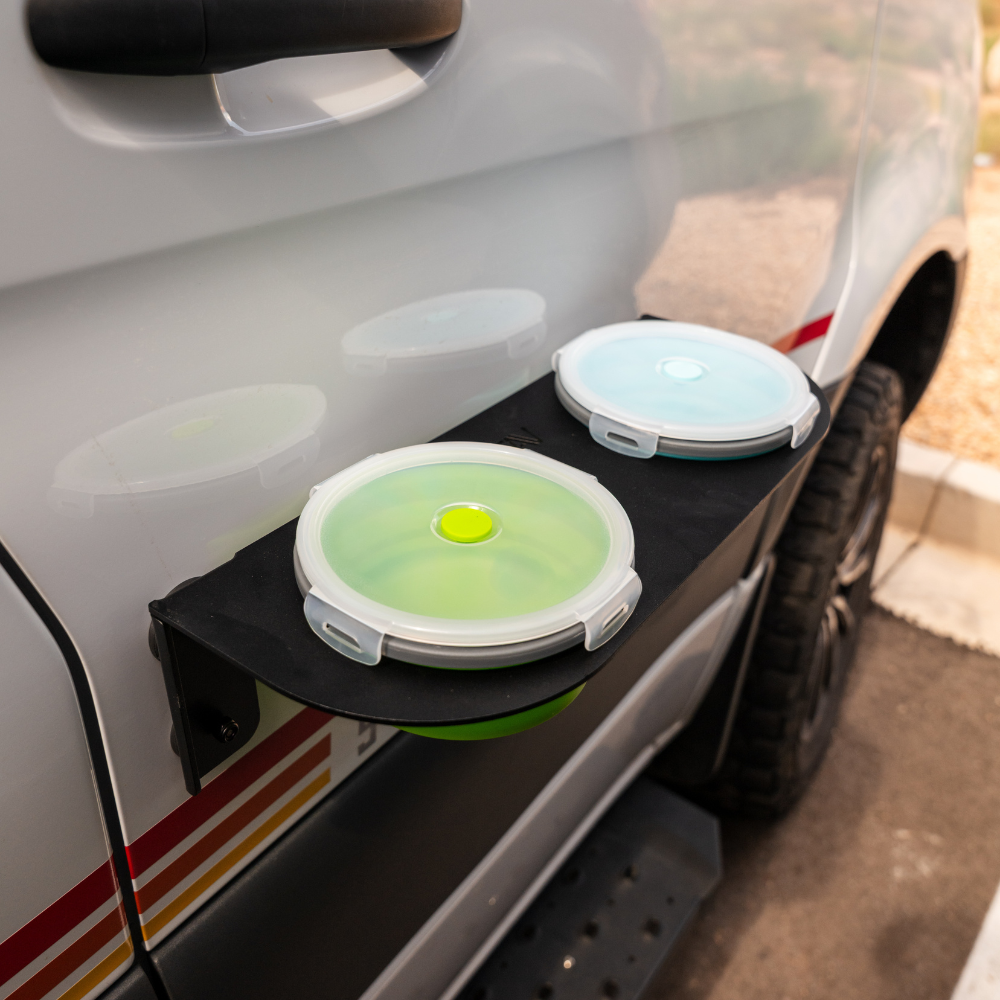 Revel Canyon Pet Bowl with twin lid-covered bowls mounted on the side of a van