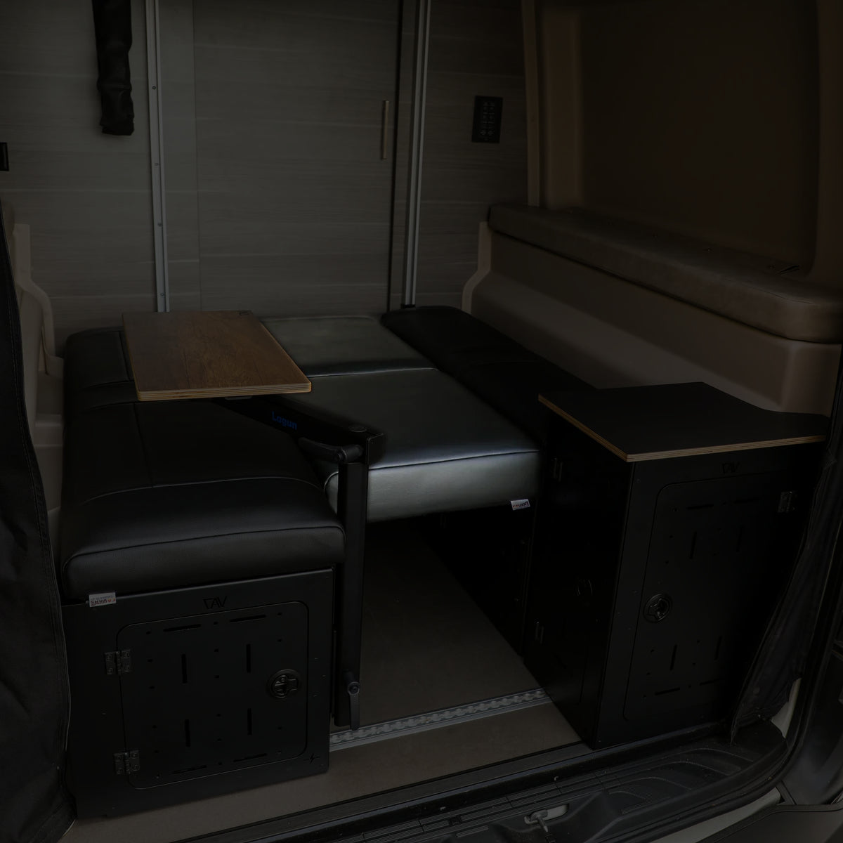 Revel day bed cushions and mount set installed in a van interior with foldable table and storage units.