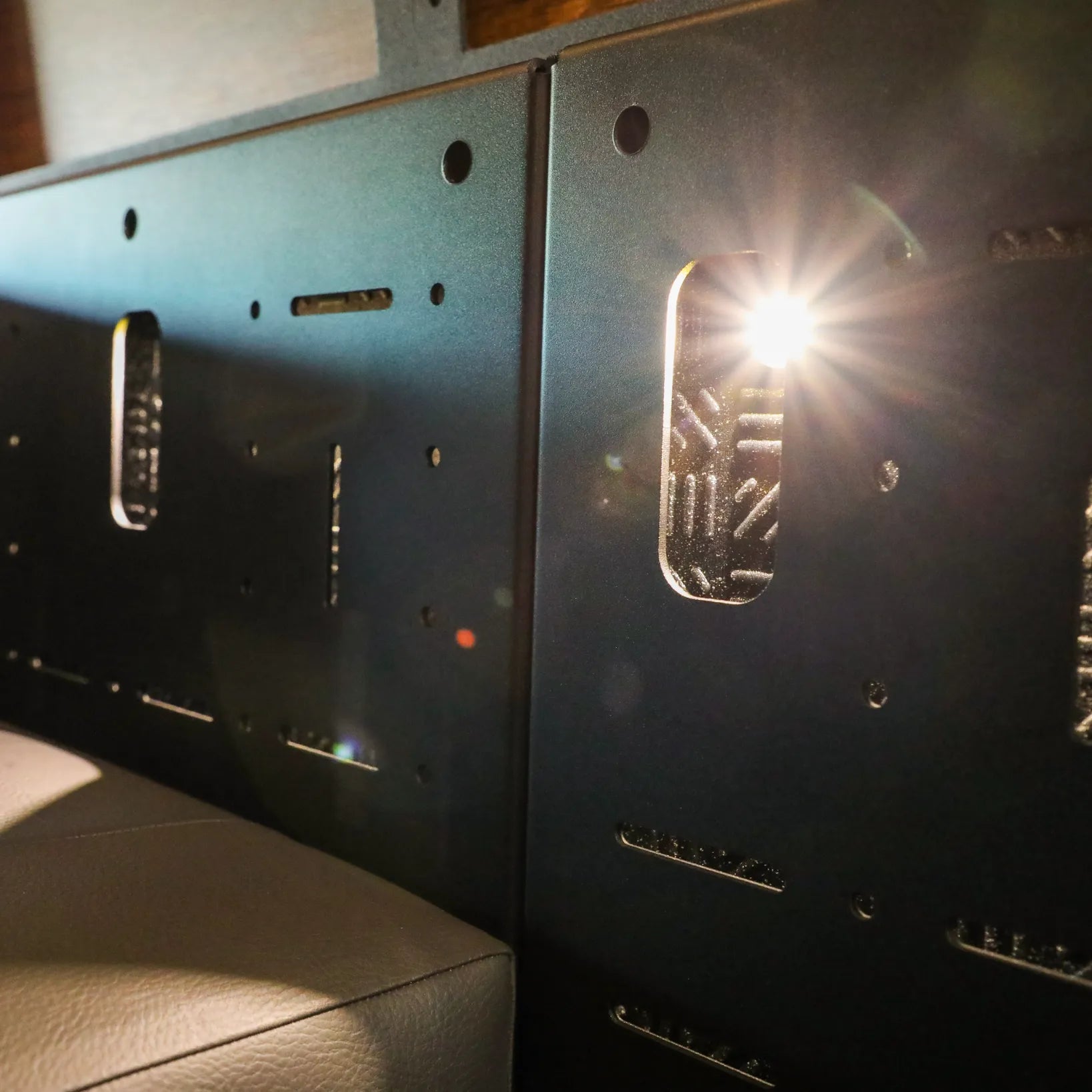 Close-up of Passenger Gear Wall Pro panel in a Storyteller Overland van with sunlight peeking through slots.
