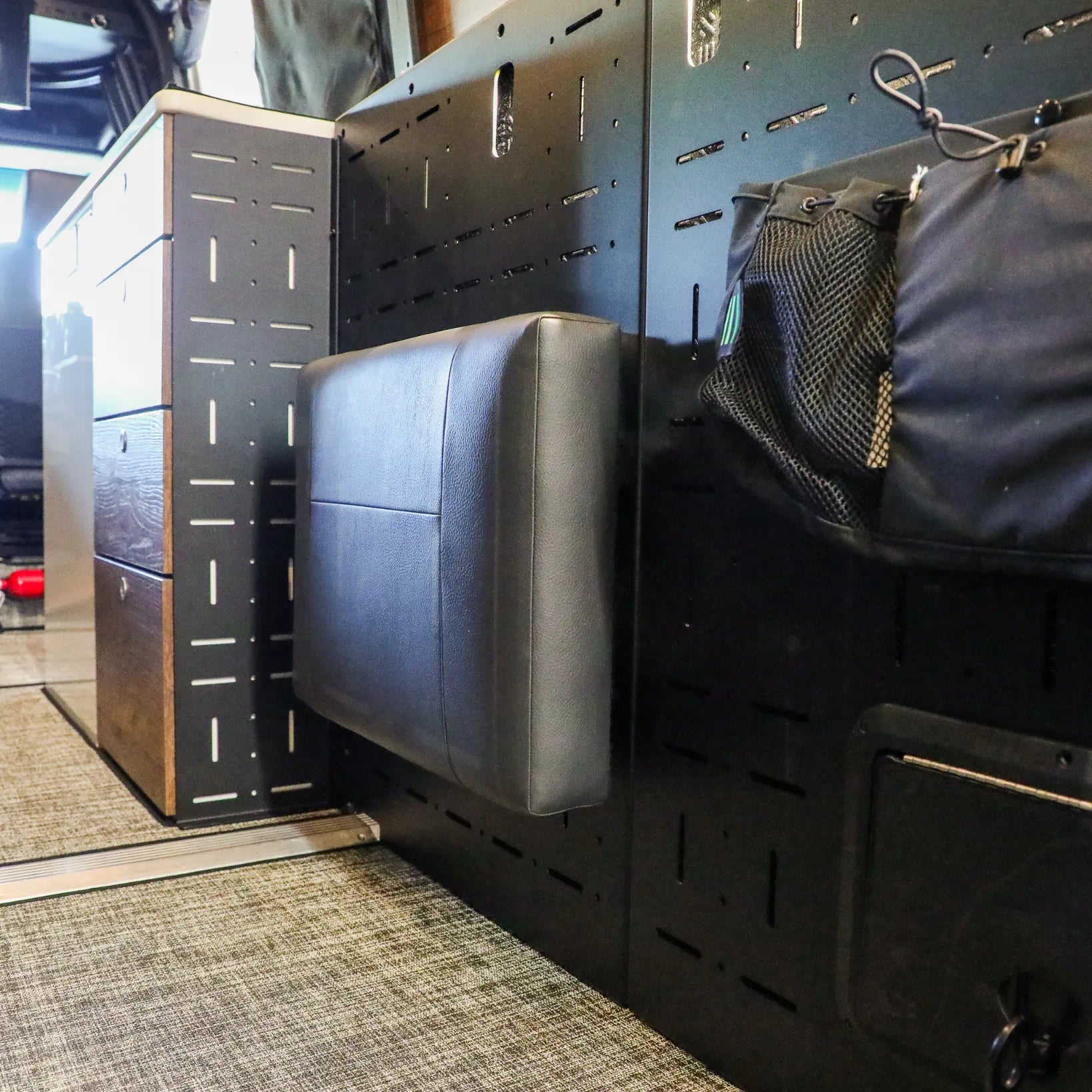 Passenger Gear Wall Pro by Storyteller Overland with mounted seat inside van interior.