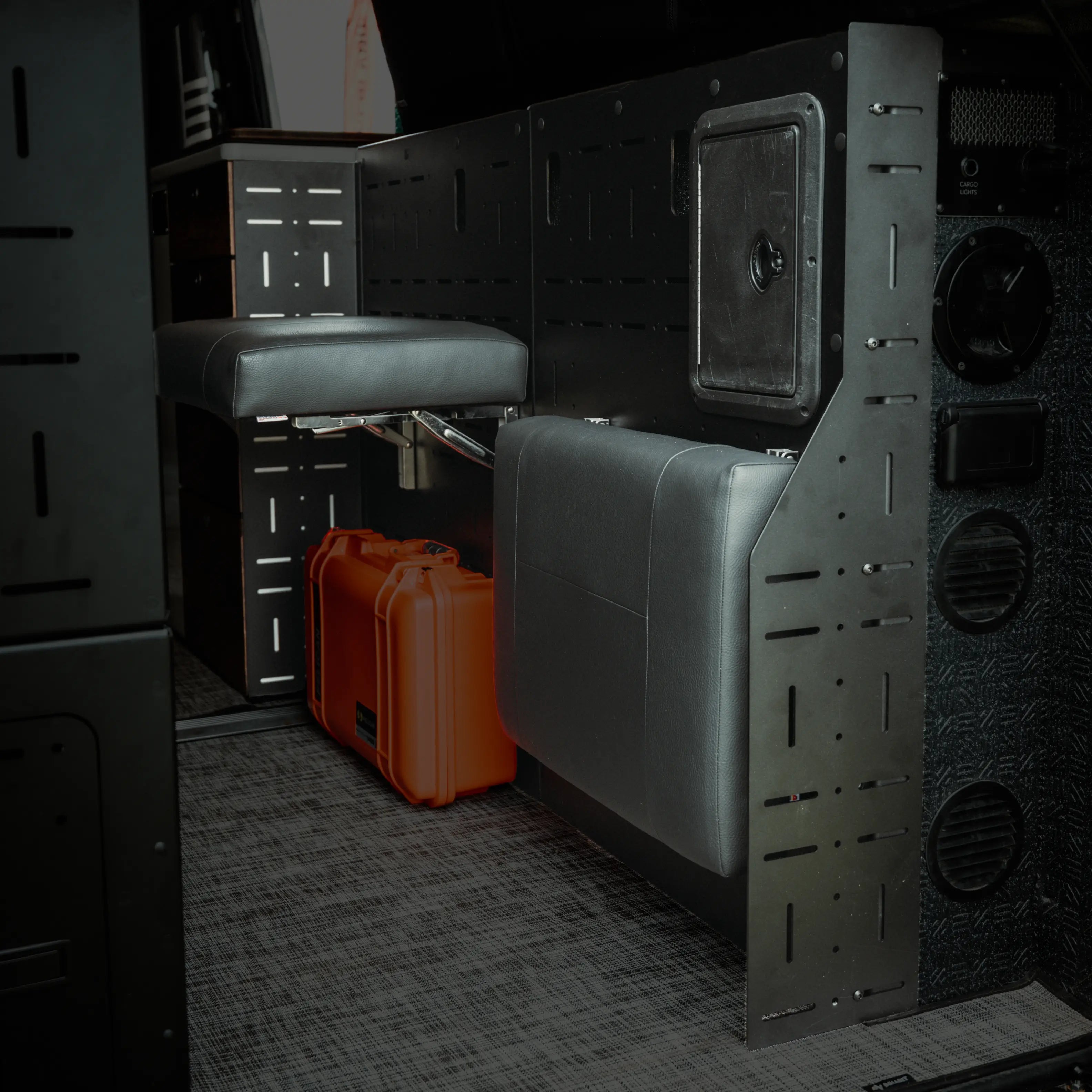 Passenger Gear Wall Pro by Storyteller Overland with fold-down seat and storage cases in van interior