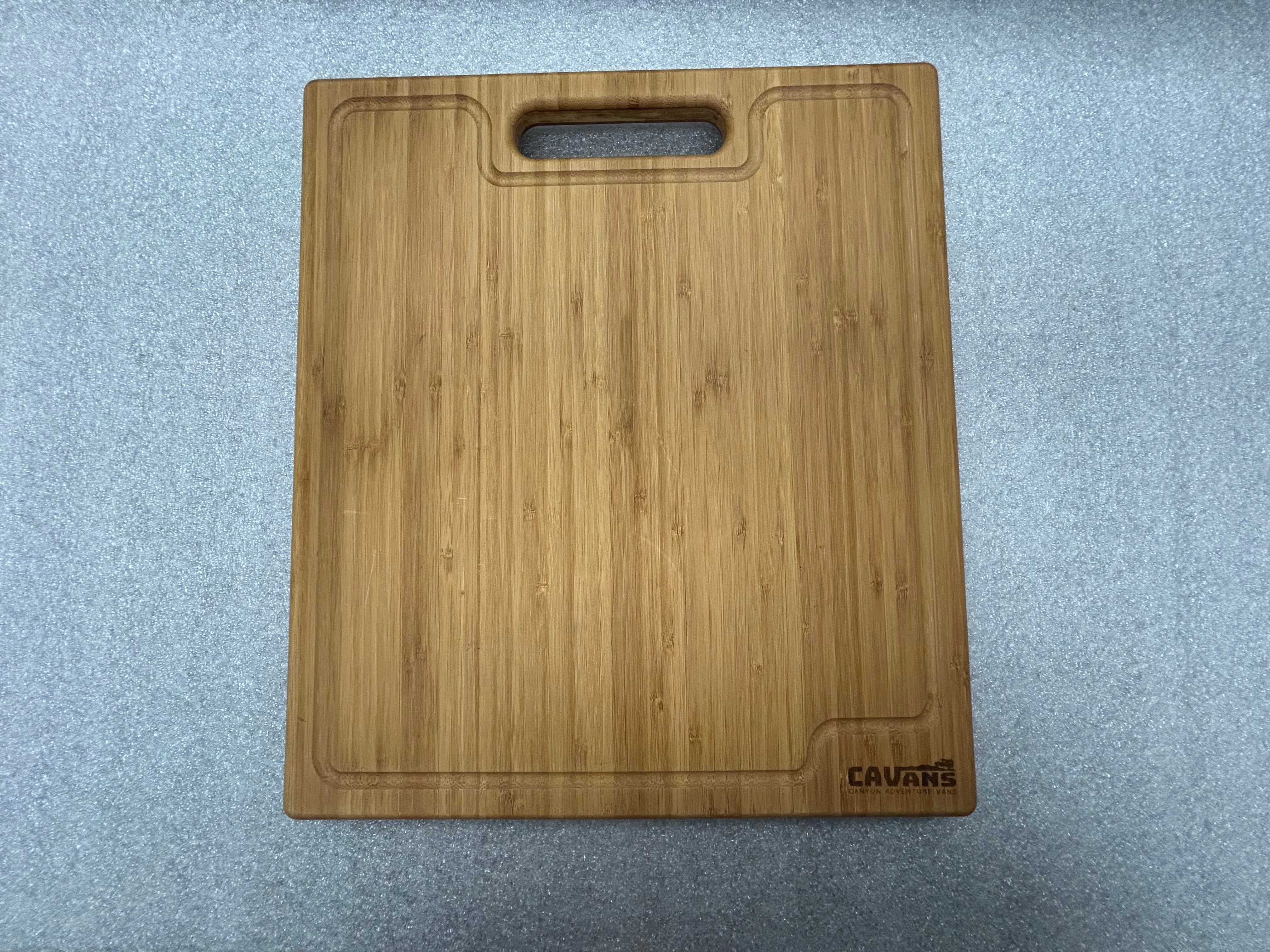 CAVANS bamboo cutting board with handle slot and juice groove, shown on a gray surface
