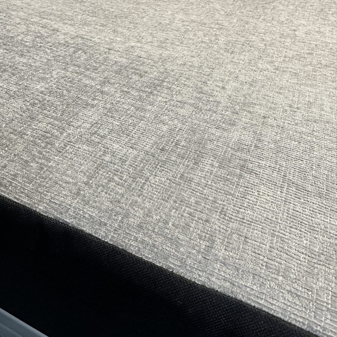 A close up of a cool grey fabric-covered bed with a Luxe6 Cool Gel Memory Foam 6" Mattress - Made for the REVEL/TERRAIN/LAUNCH.