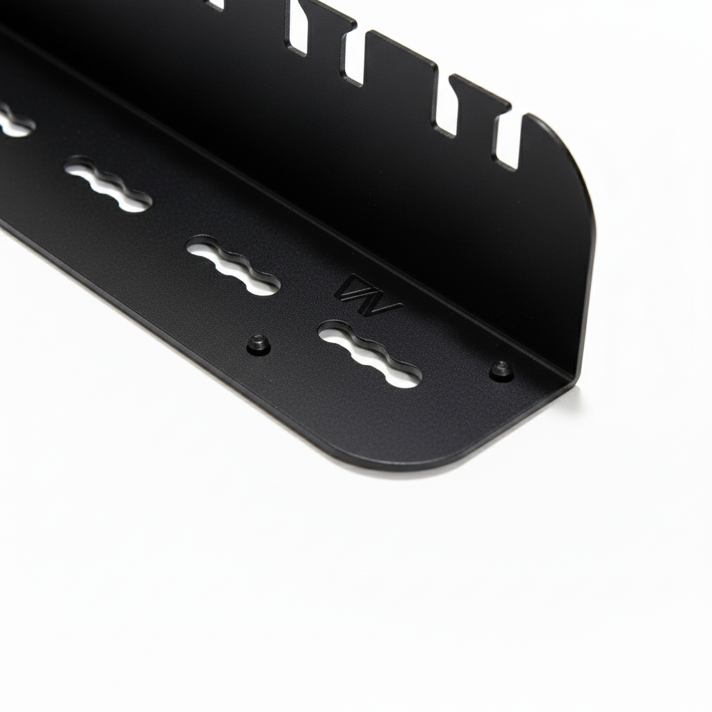 Close-up of black Revel outdoor utility shelf with cut-out slots and mounting holes on white background.