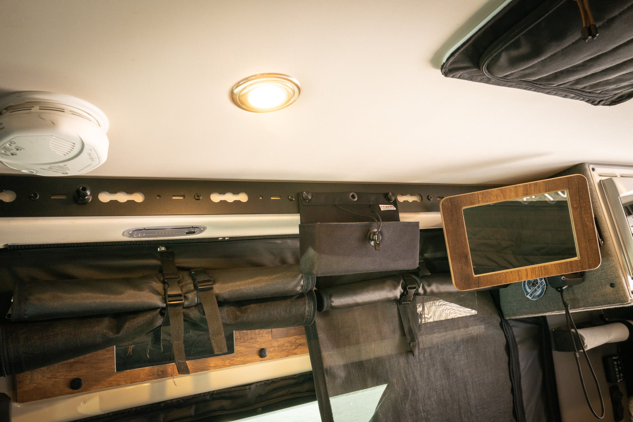 L-Track Pro system installed above the sliding door in a Storyteller Overland Mode van interior.