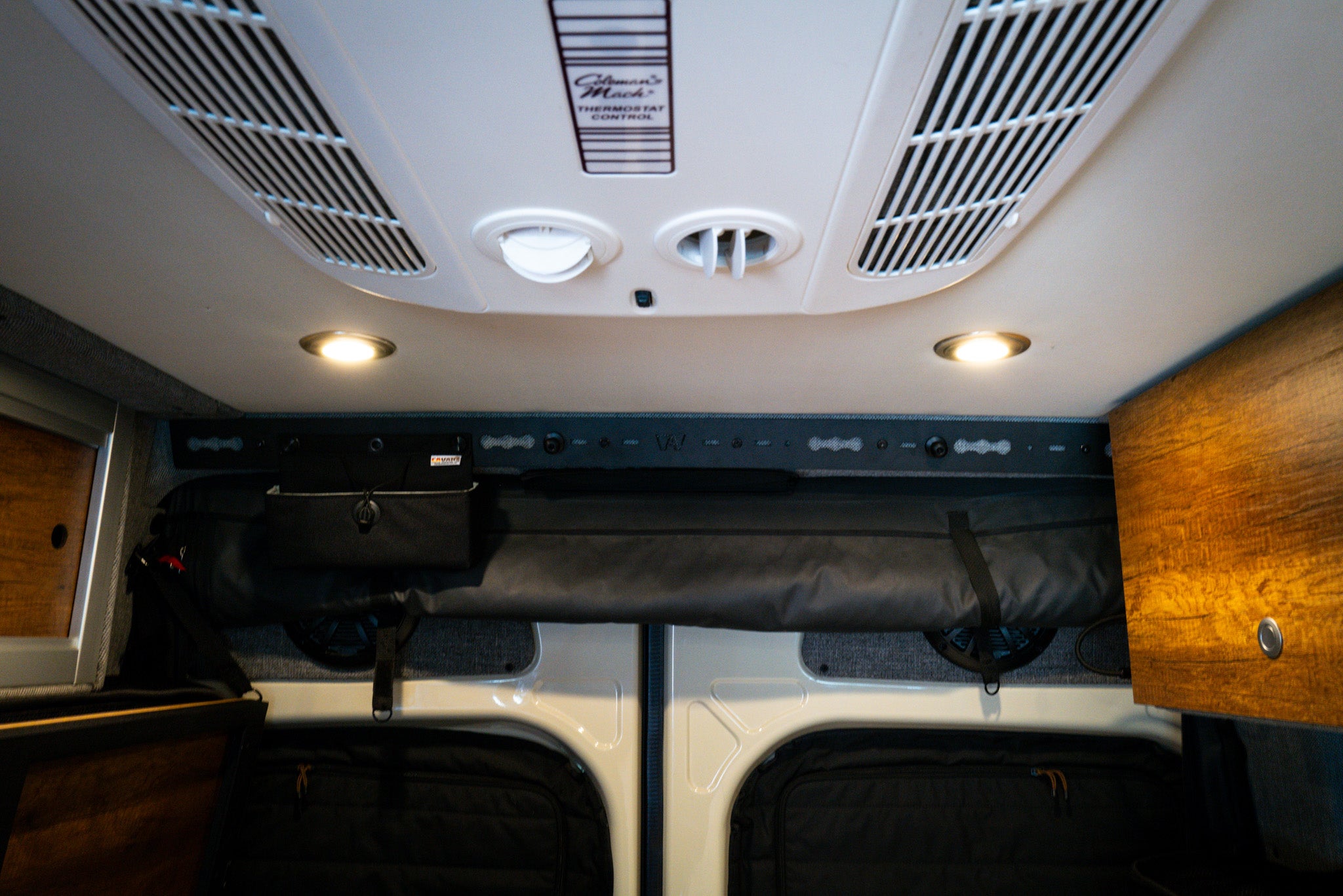 L-Track Pro mounted above rear doors in Storyteller Overland Mode van interior ceiling view.