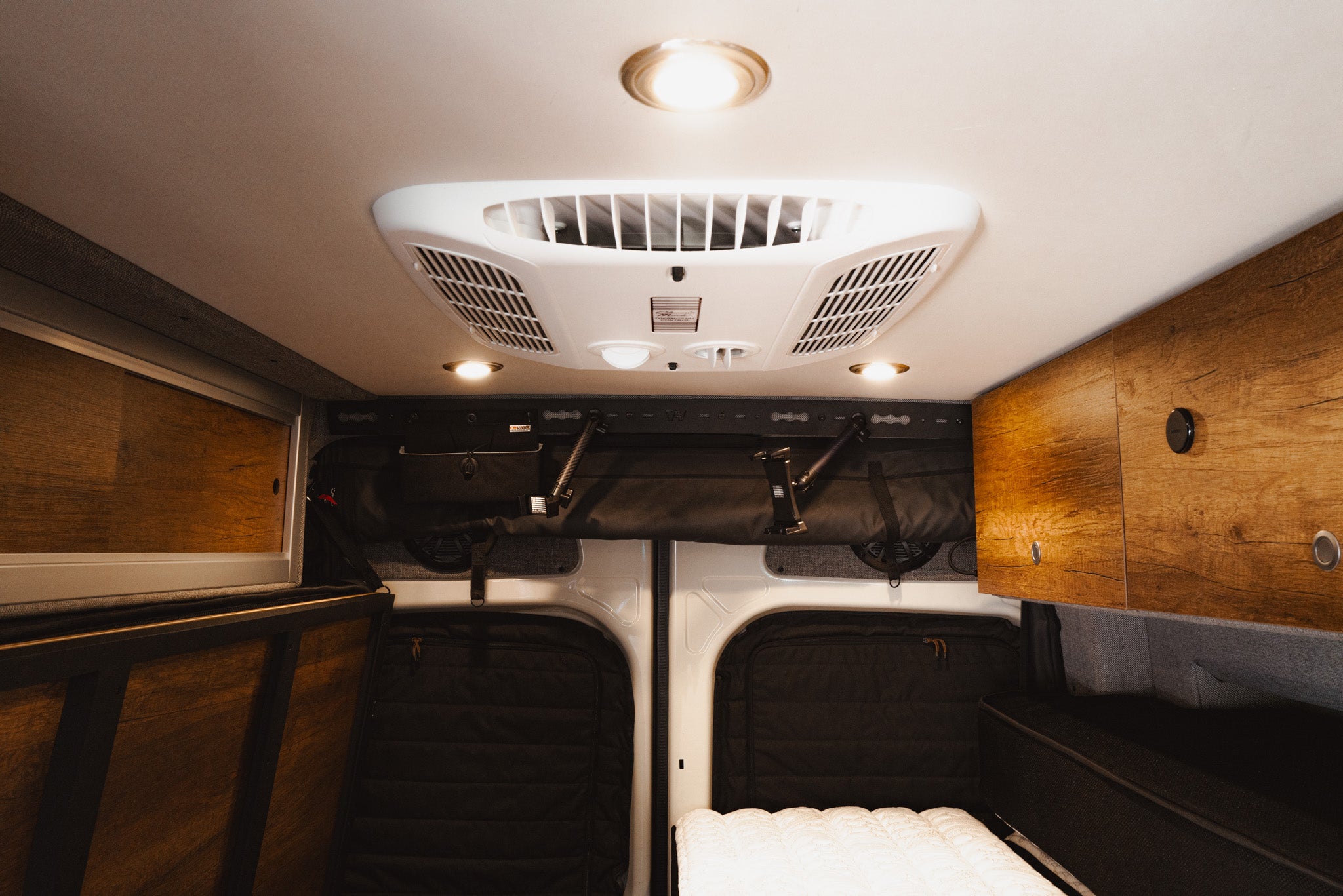 Interior view of van ceiling showing L-Track Pro system for overhead storage and sliding doors.