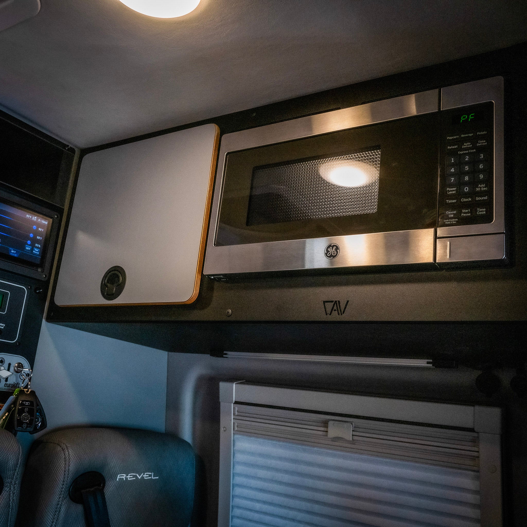 Revel CAV microwave overhead cabinet kit installed above the counter in a van interior.