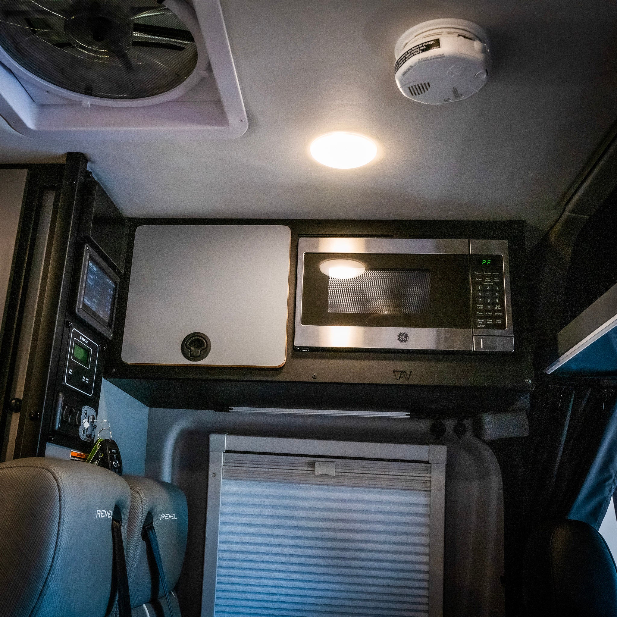 Revel overhead cabinet kit with built-in GE microwave inside van interior ceiling setup.