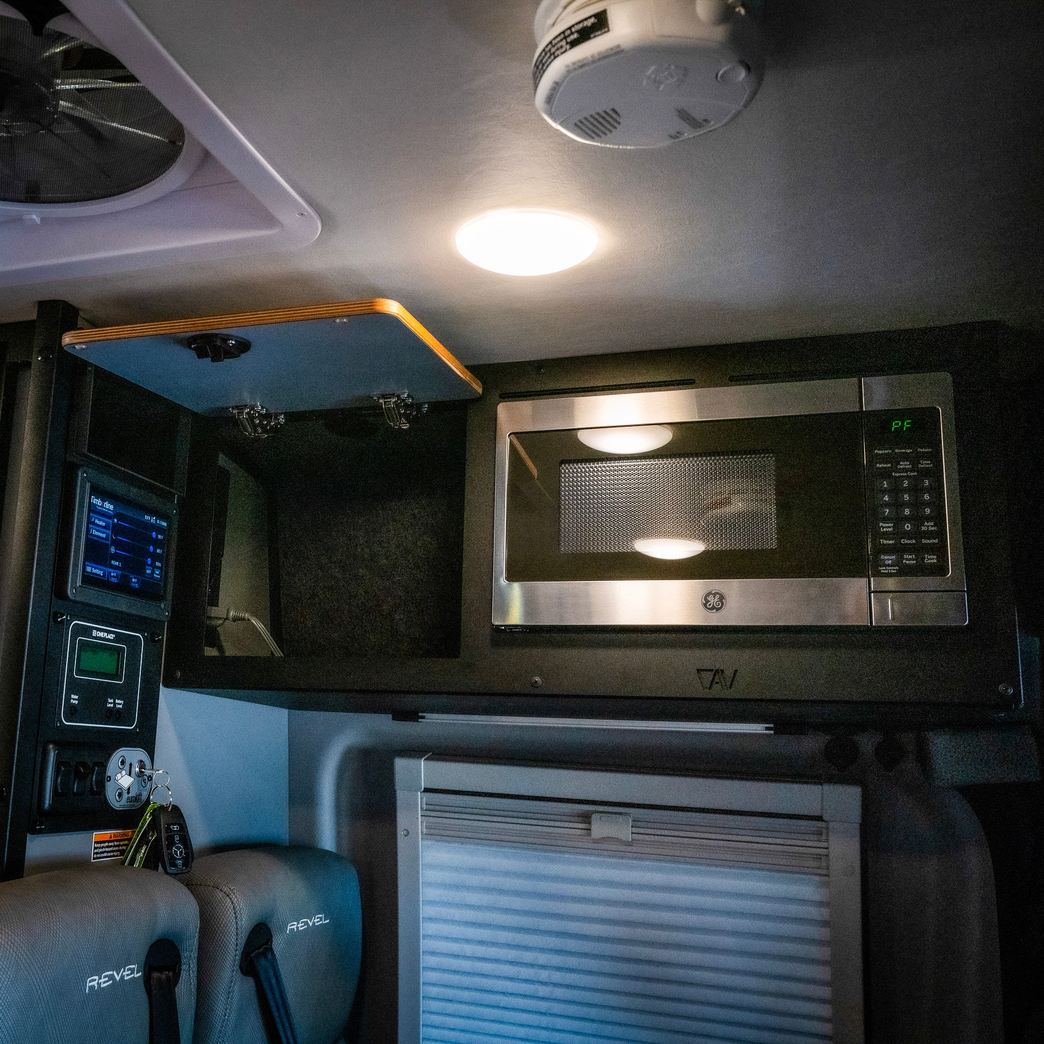 Revel microwave overhead cabinet kit with GE microwave installed in a van interior.