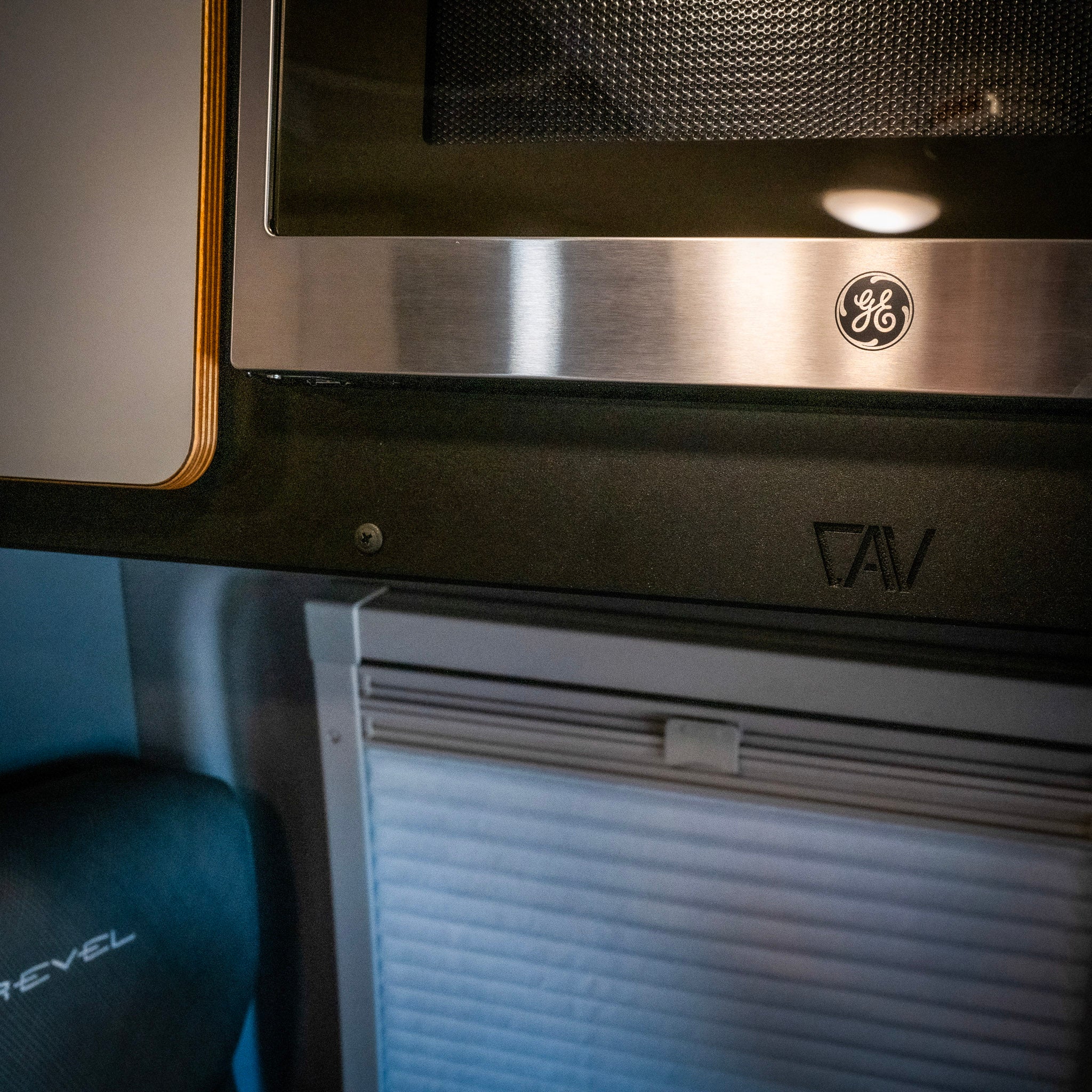 CAV microwave overhead cabinet kit installed in a Revel van interior under GE microwave