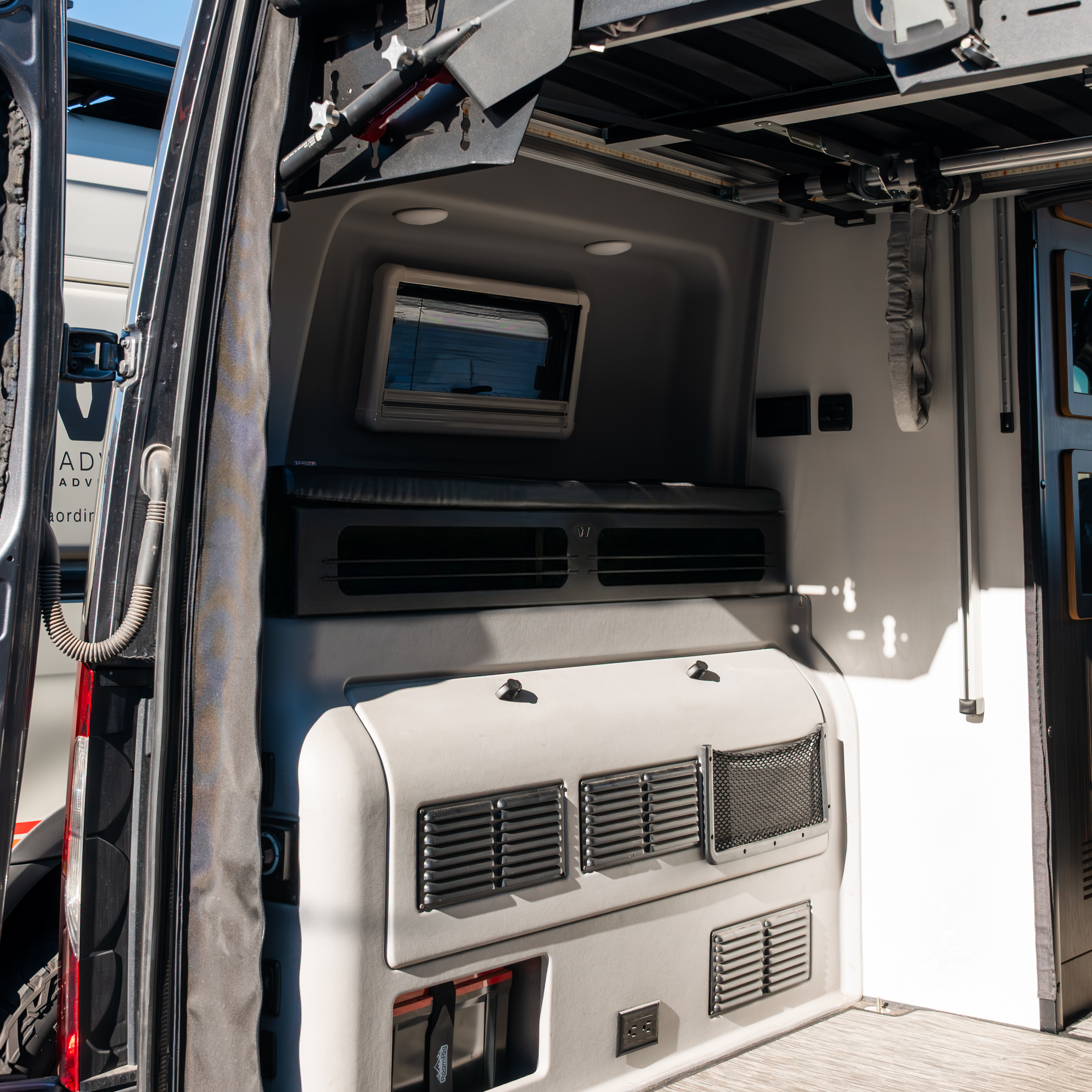 Revel 6-inch bed risers installed in a van sleeping area with window and storage compartments