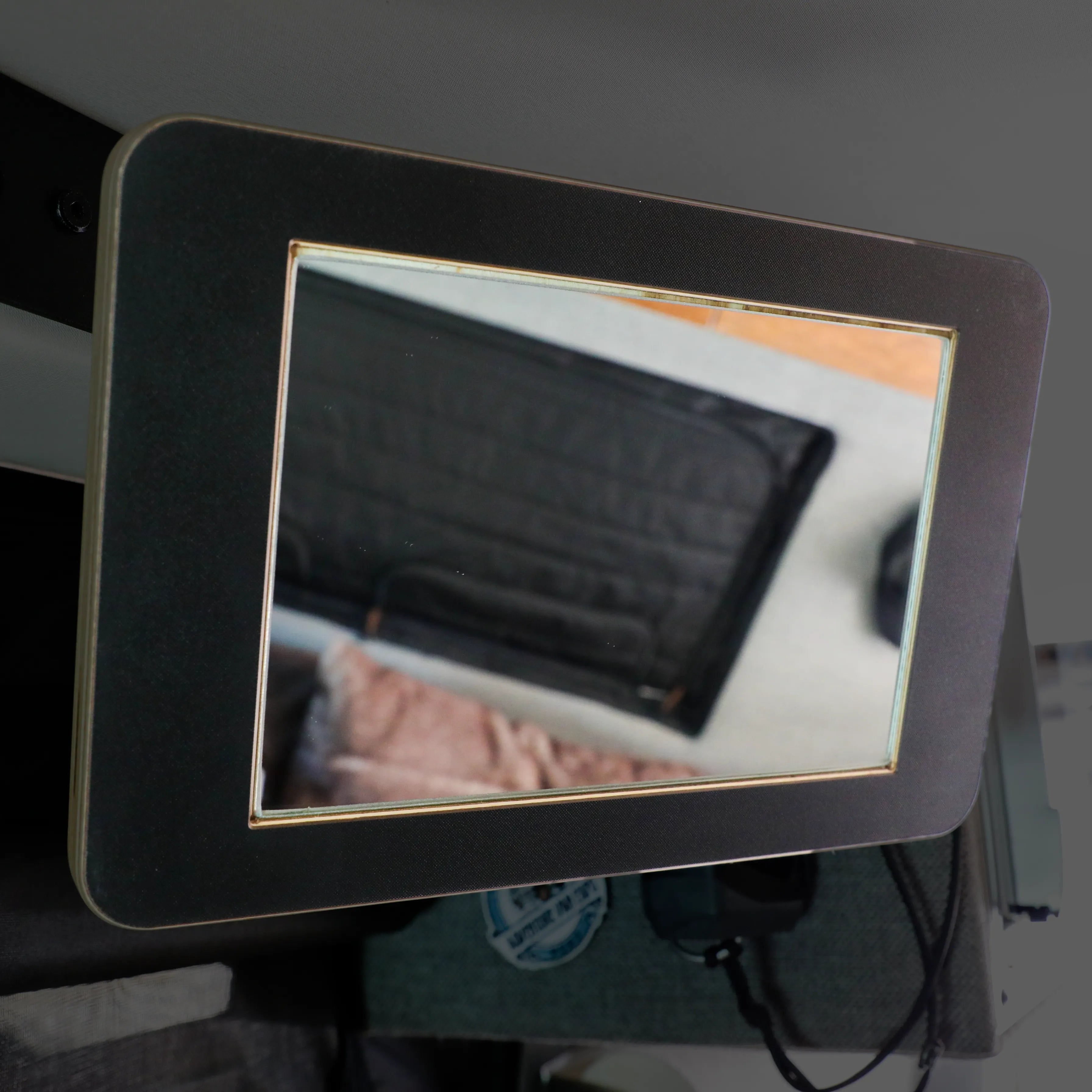 Mounted Storyteller L-Track PRO mirror inside van reflecting soft interior features.