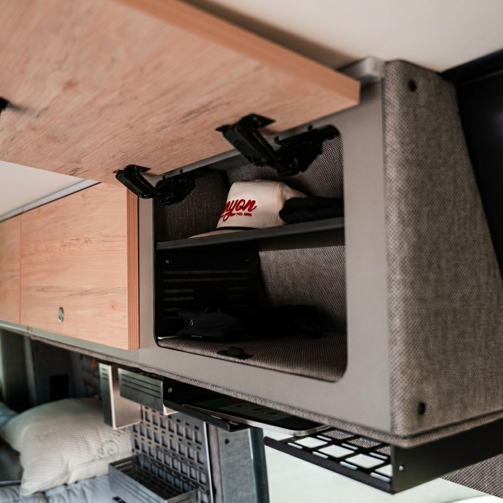 Open Storyteller cabinet shelf in a van interior showing soft-close hinges and organized storage space.