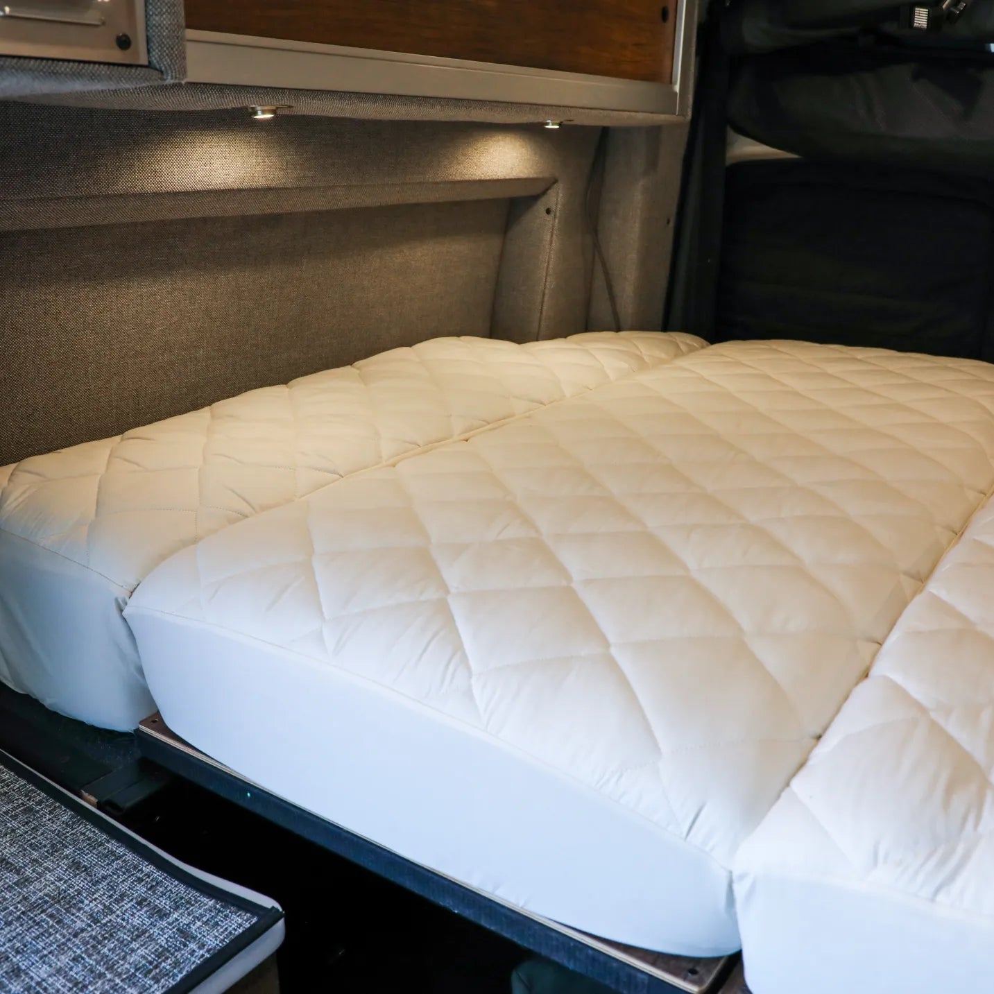Ultra Luxe mattress protector pad on a fully extended bed inside a van interior