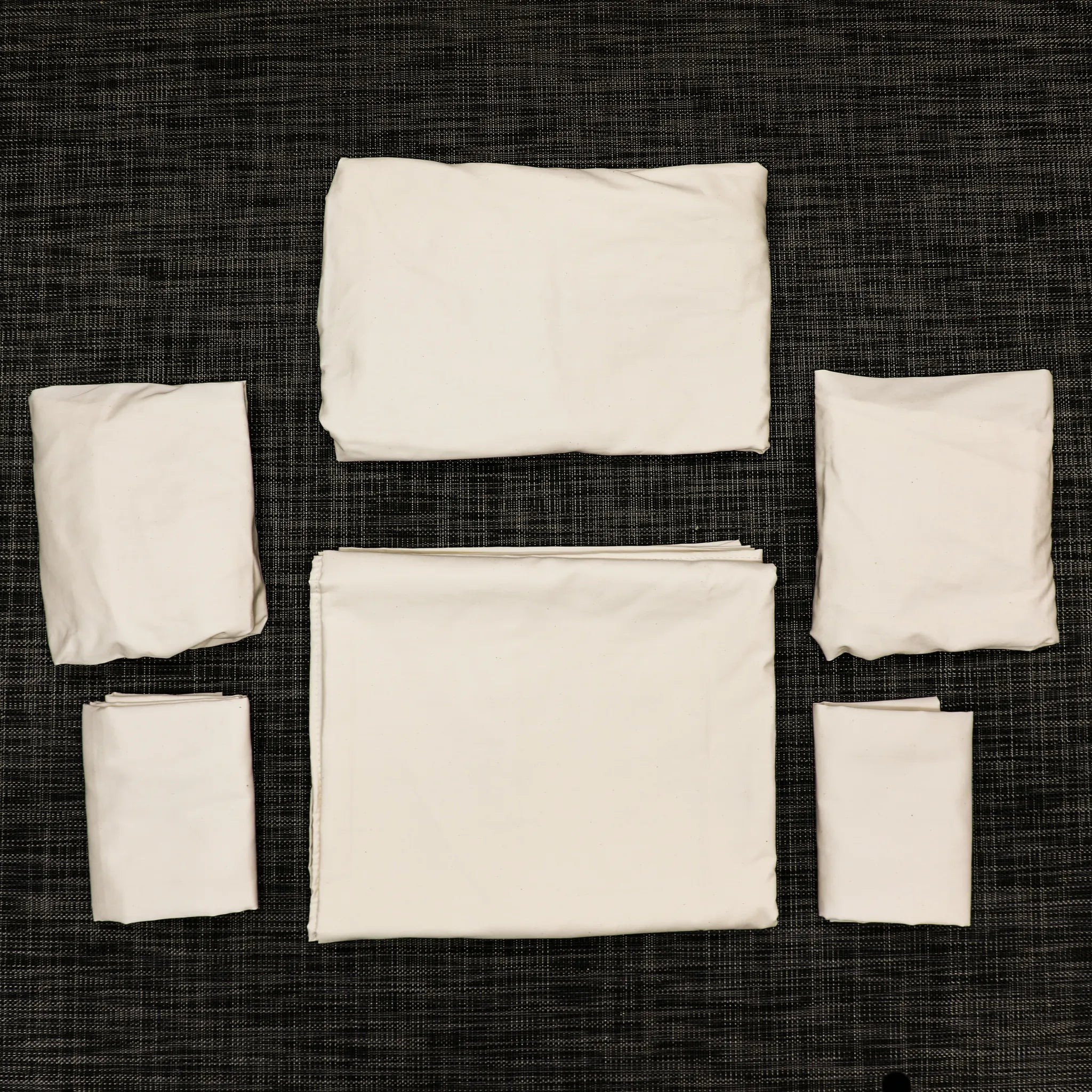 White Dream Bundle bedding set for Revel, Terrain, and Launch vans laid out on dark fabric background.