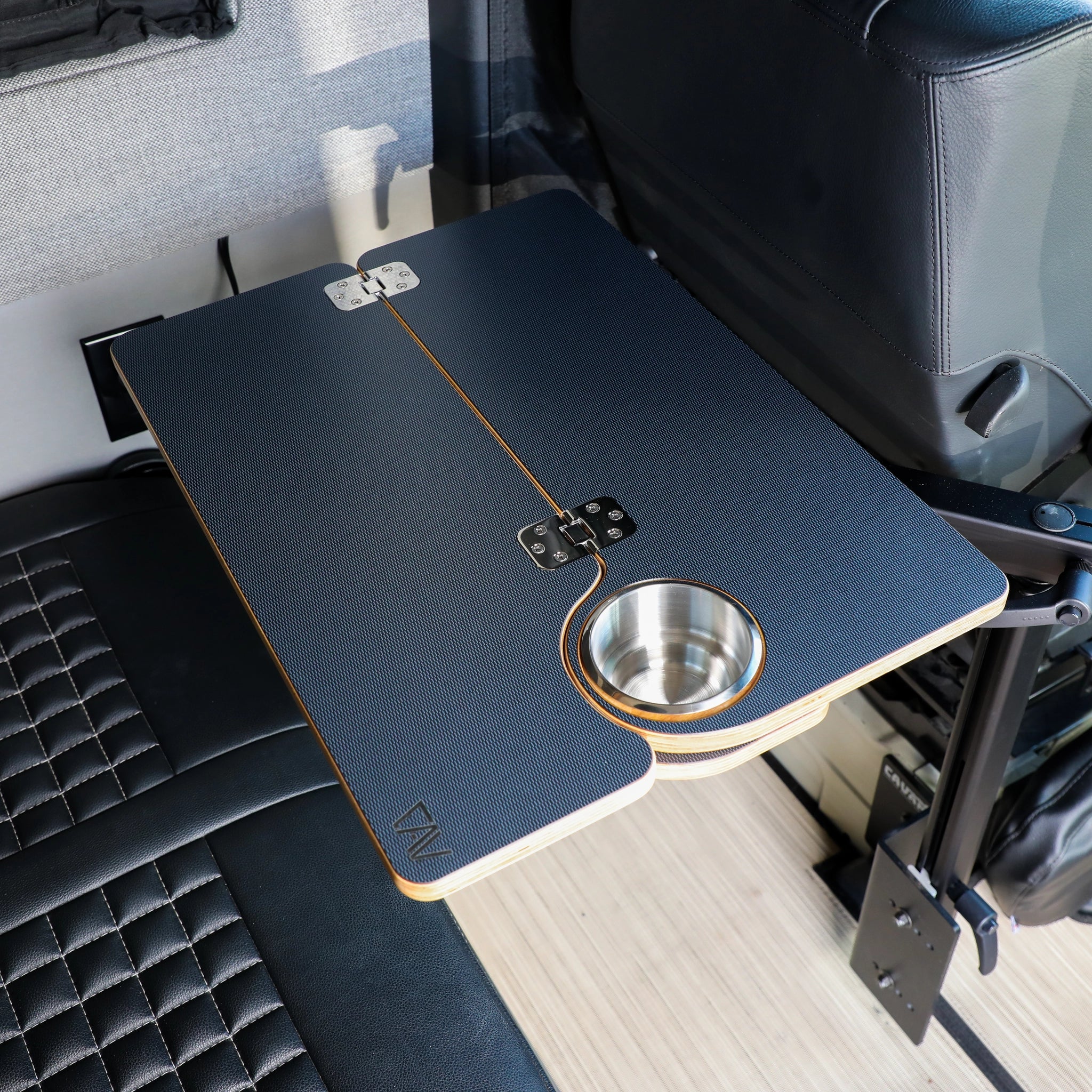 Solo Folding Table Top mounted next to a van seat with built-in cup holder and hinge detail.