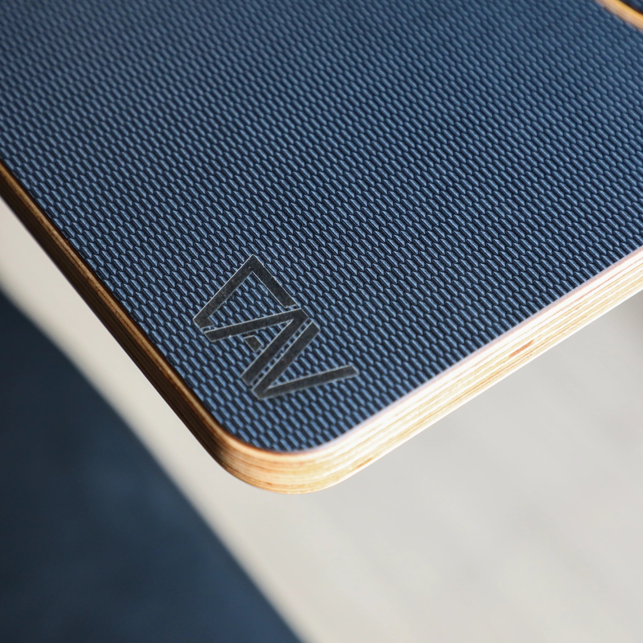 Close-up of CAV Solo Folding Table Top with textured blue surface and layered wood edge