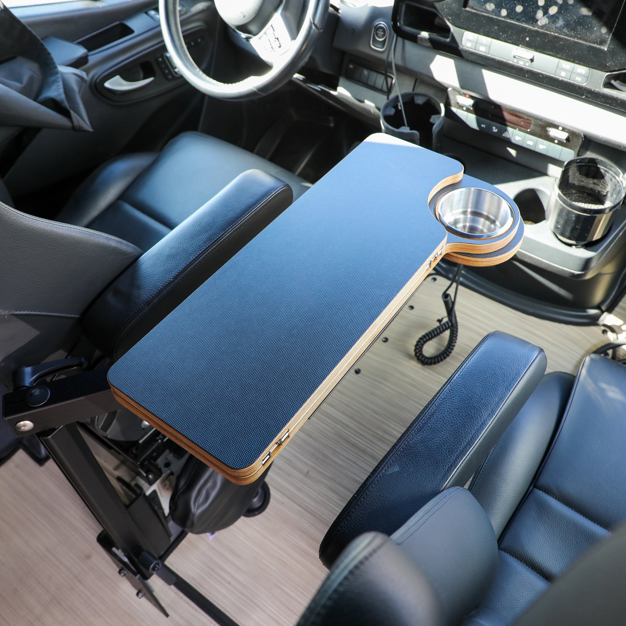 Revel van interior with folding armrest table featuring cupholder between driver and passenger seats