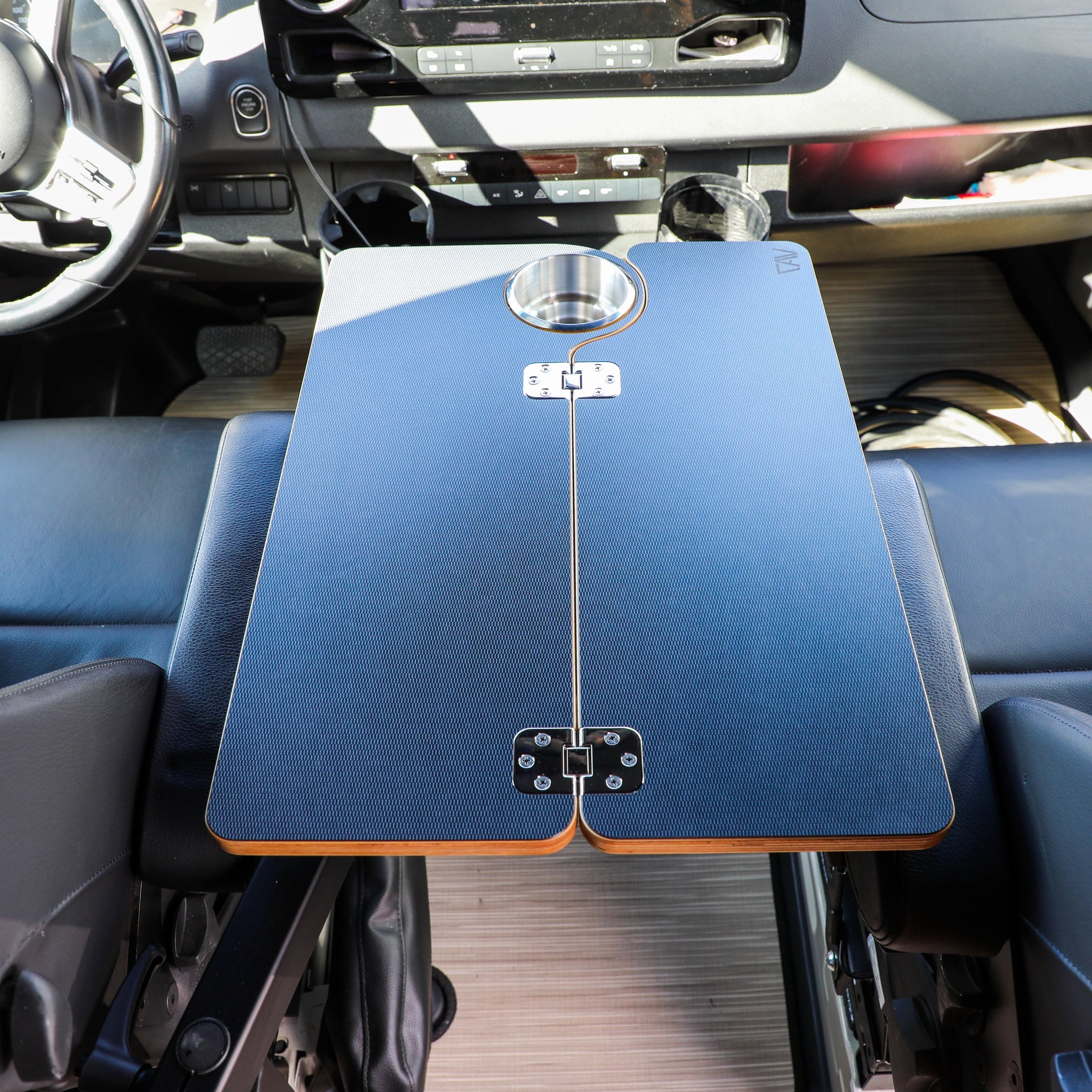 Solo Folding Table Top by CAV installed in van cockpit with cup holder and hinge detail visible