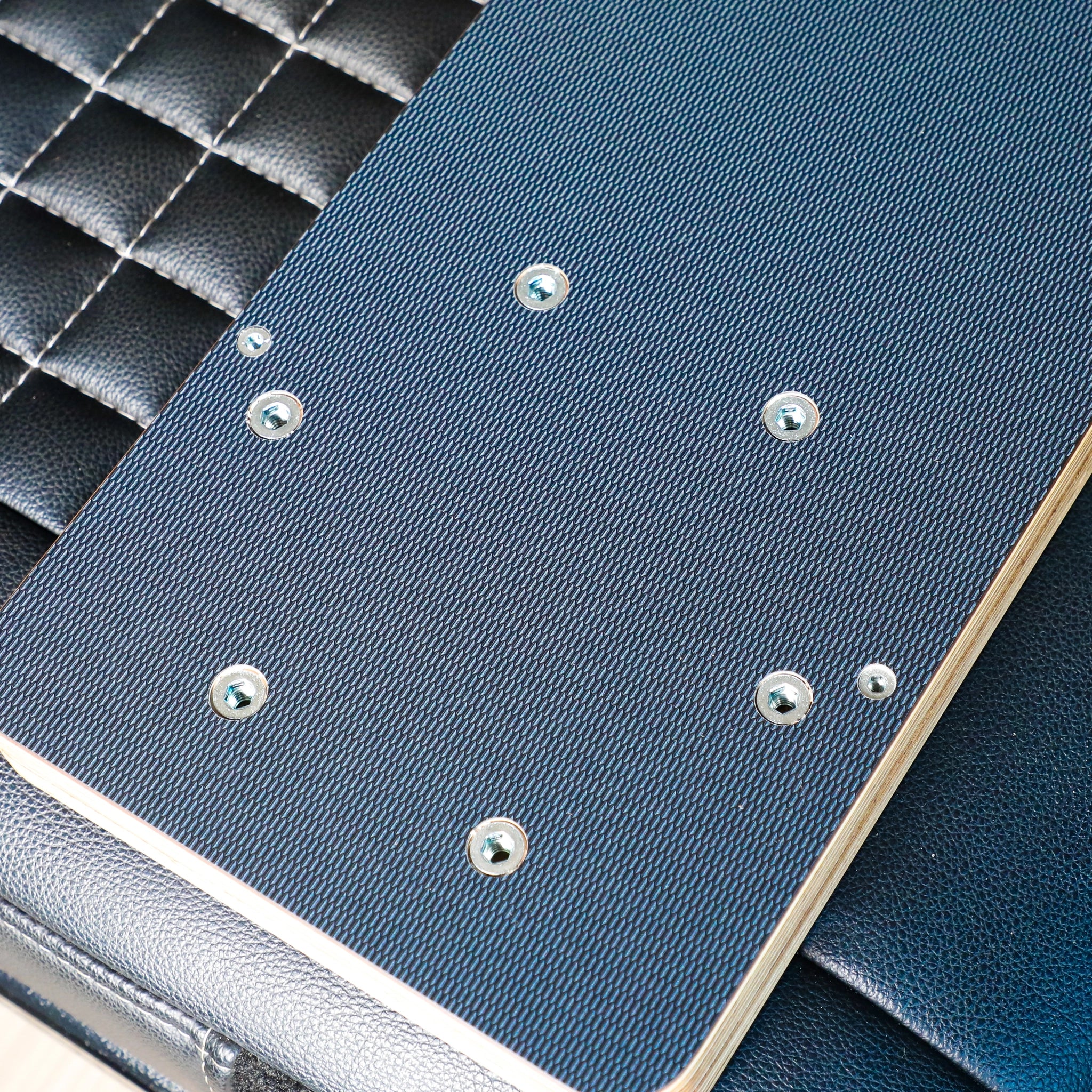 Solo Folding Table Top by GH1 shown folded on a black leather van seat with visible mounting hardware.