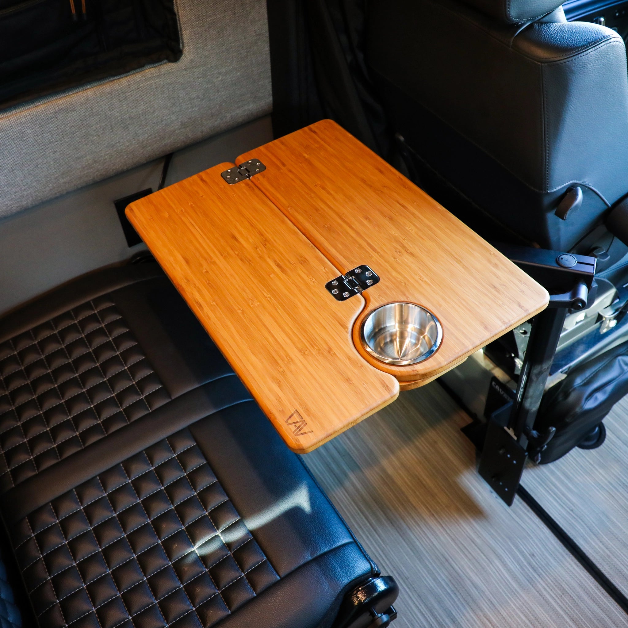 Solo Folding Table Top by CAV mounted between van seats with built-in cup holder.