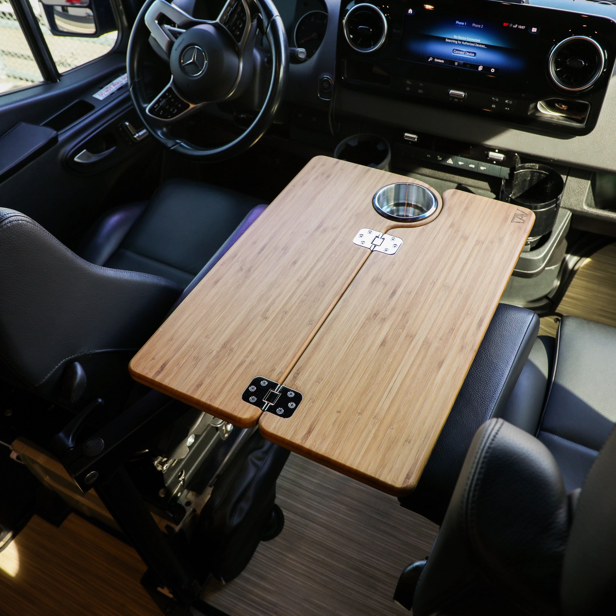 Revel bamboo table with cupholder set up between front seats in a van cockpit.
