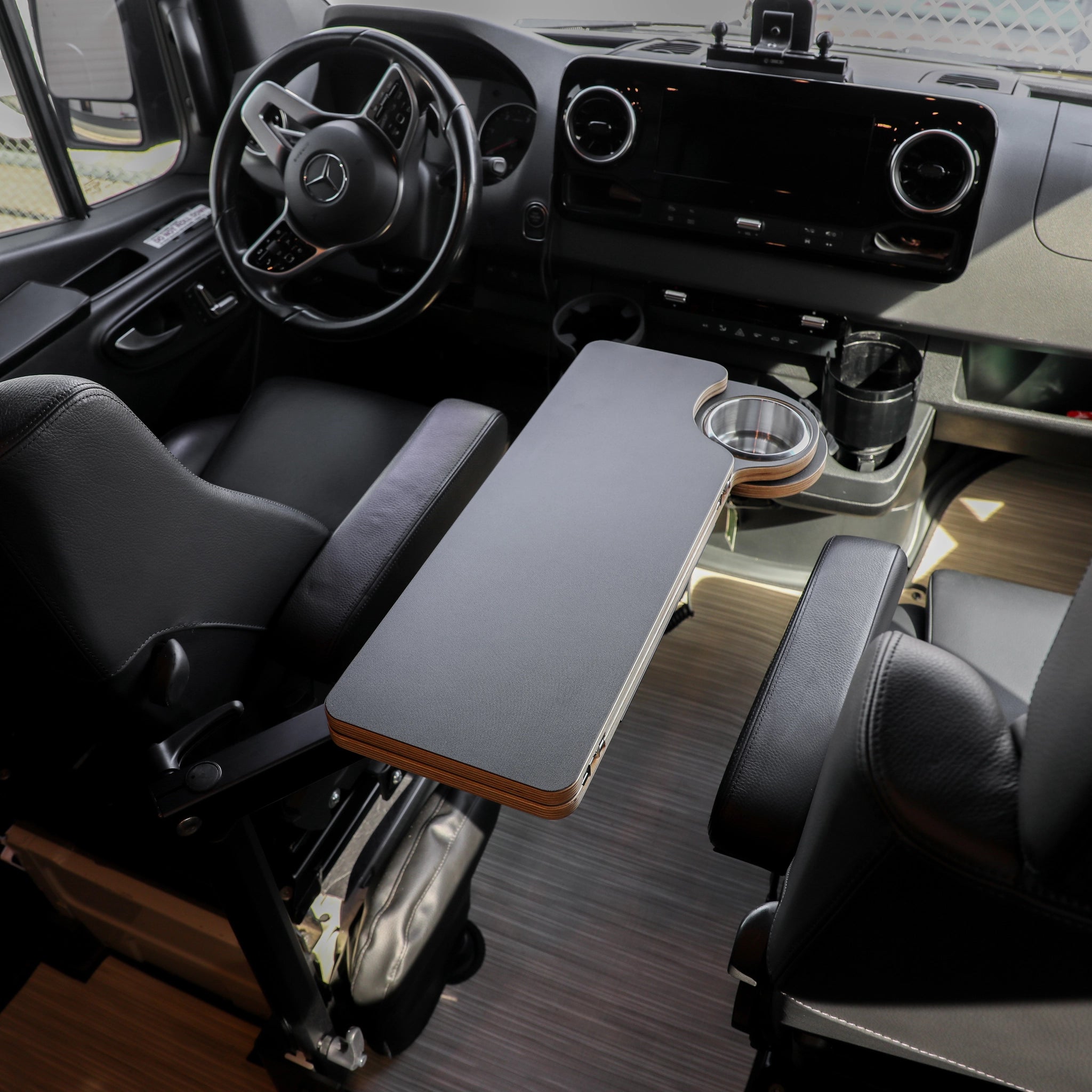 Carbon black folding console table installed between front seats in a Revel van interior.