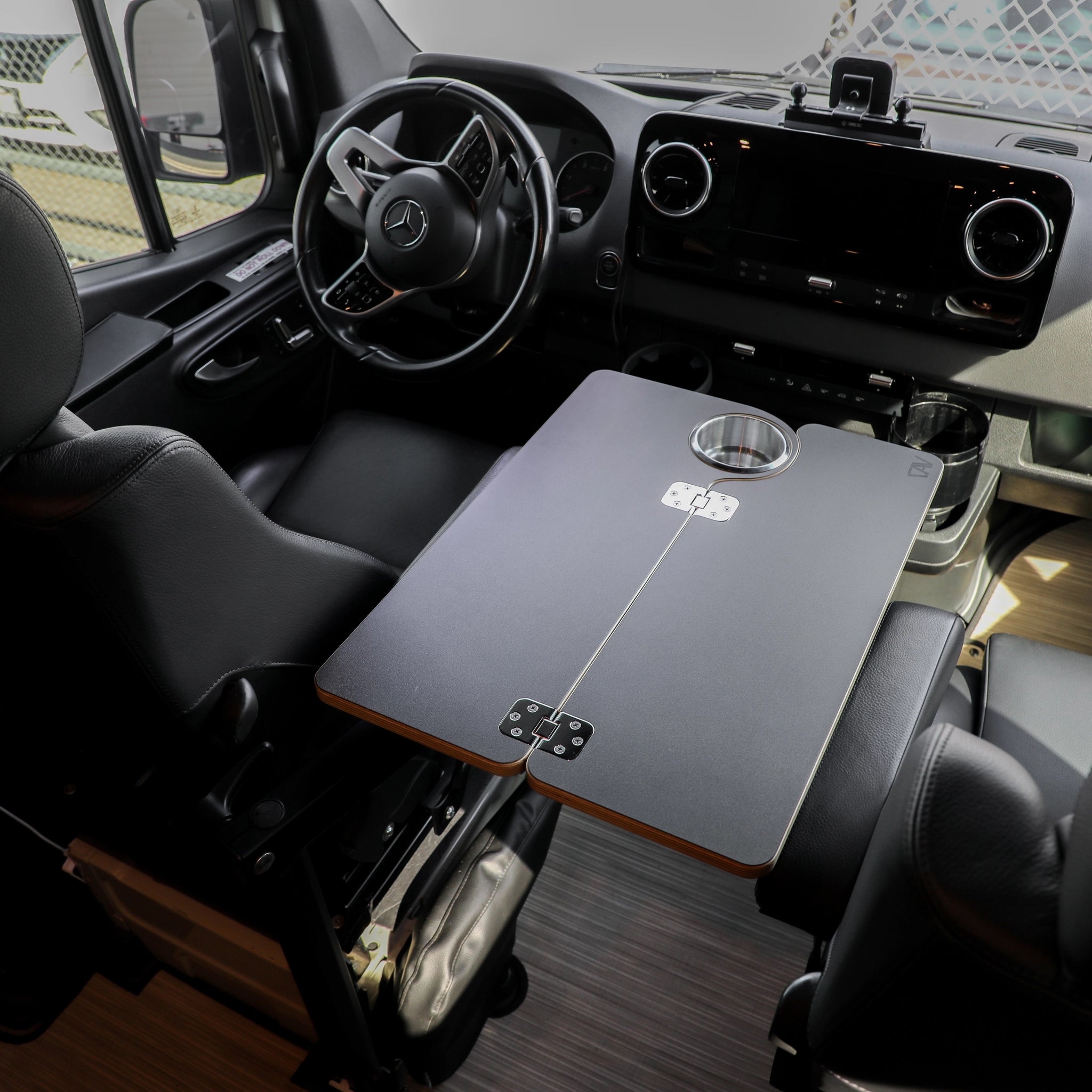Carbon black folding console table installed between front seats in a Revel van interior.