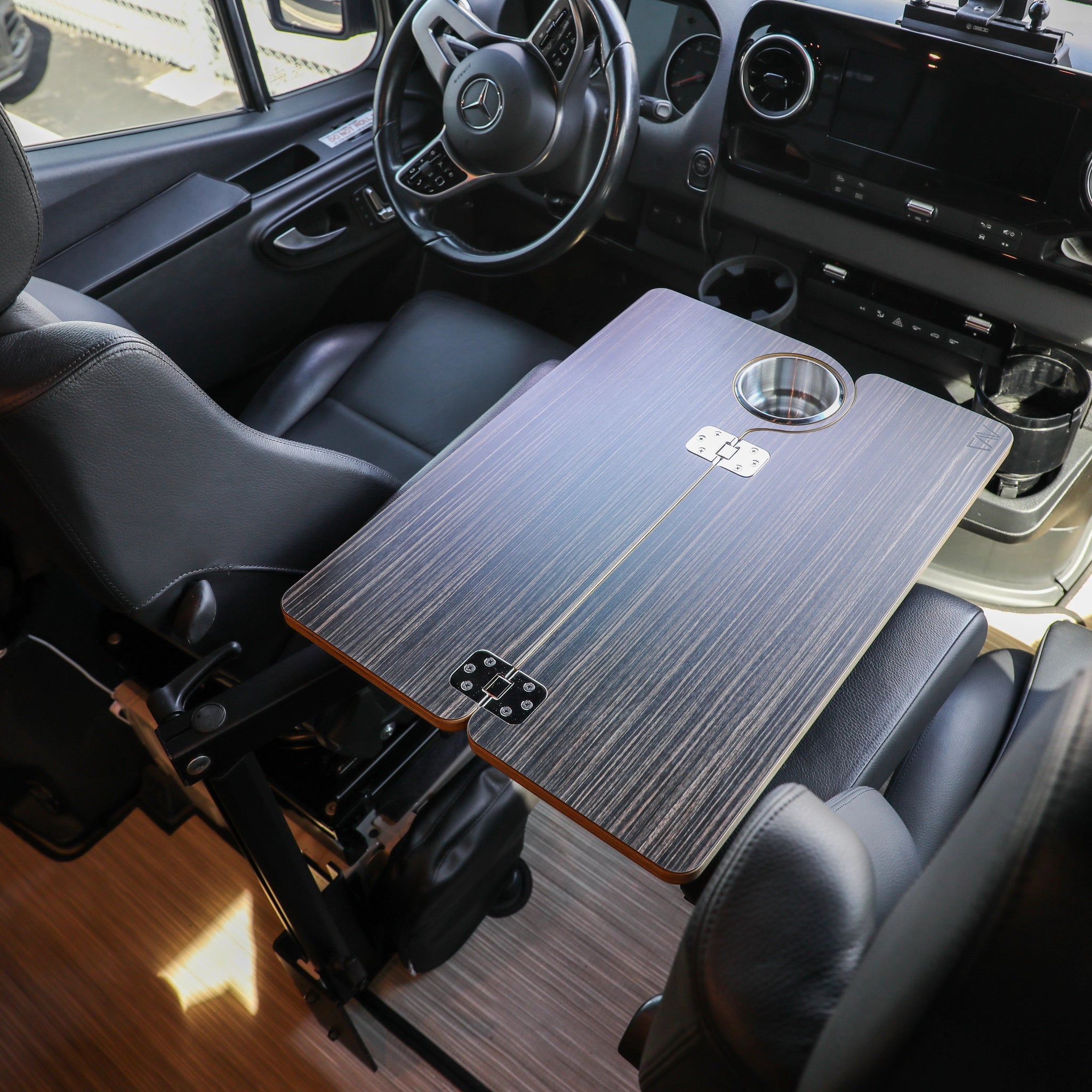 Revel van interior with mounted signature table between two leather captain chairs