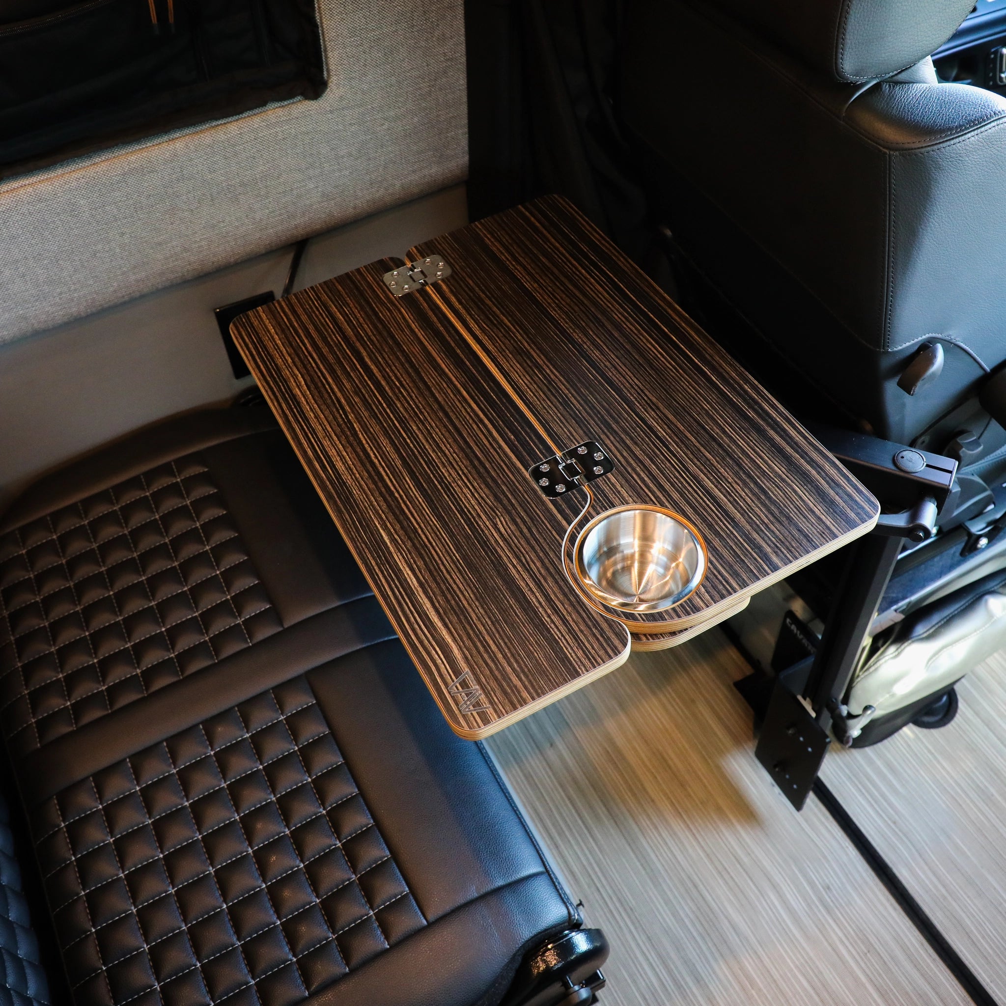 Solo folding table top with cup holder mounted between van seat and wall panel
