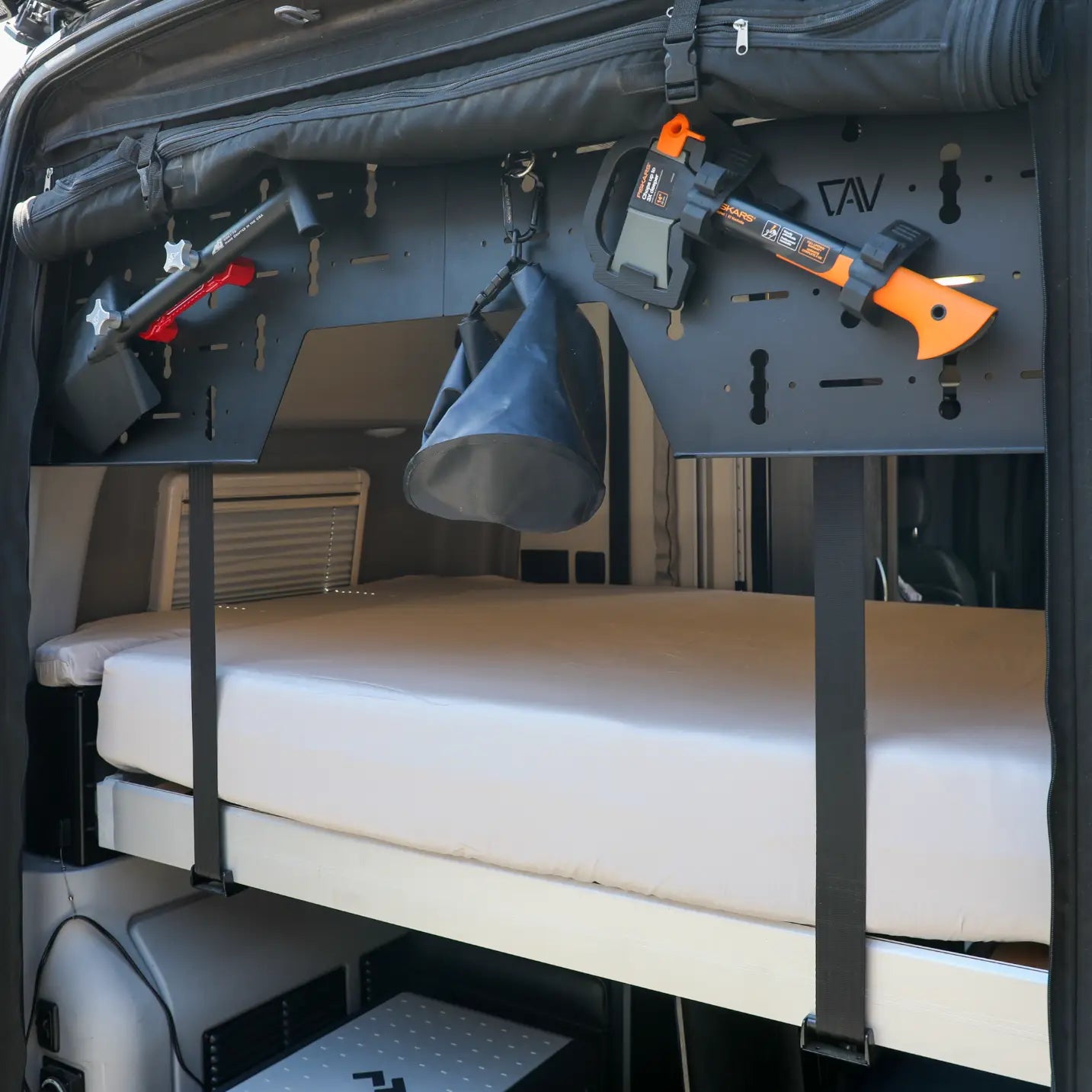 Ultra Luxe Dream Sheets by CAV on a bed inside a van with mounted tools above