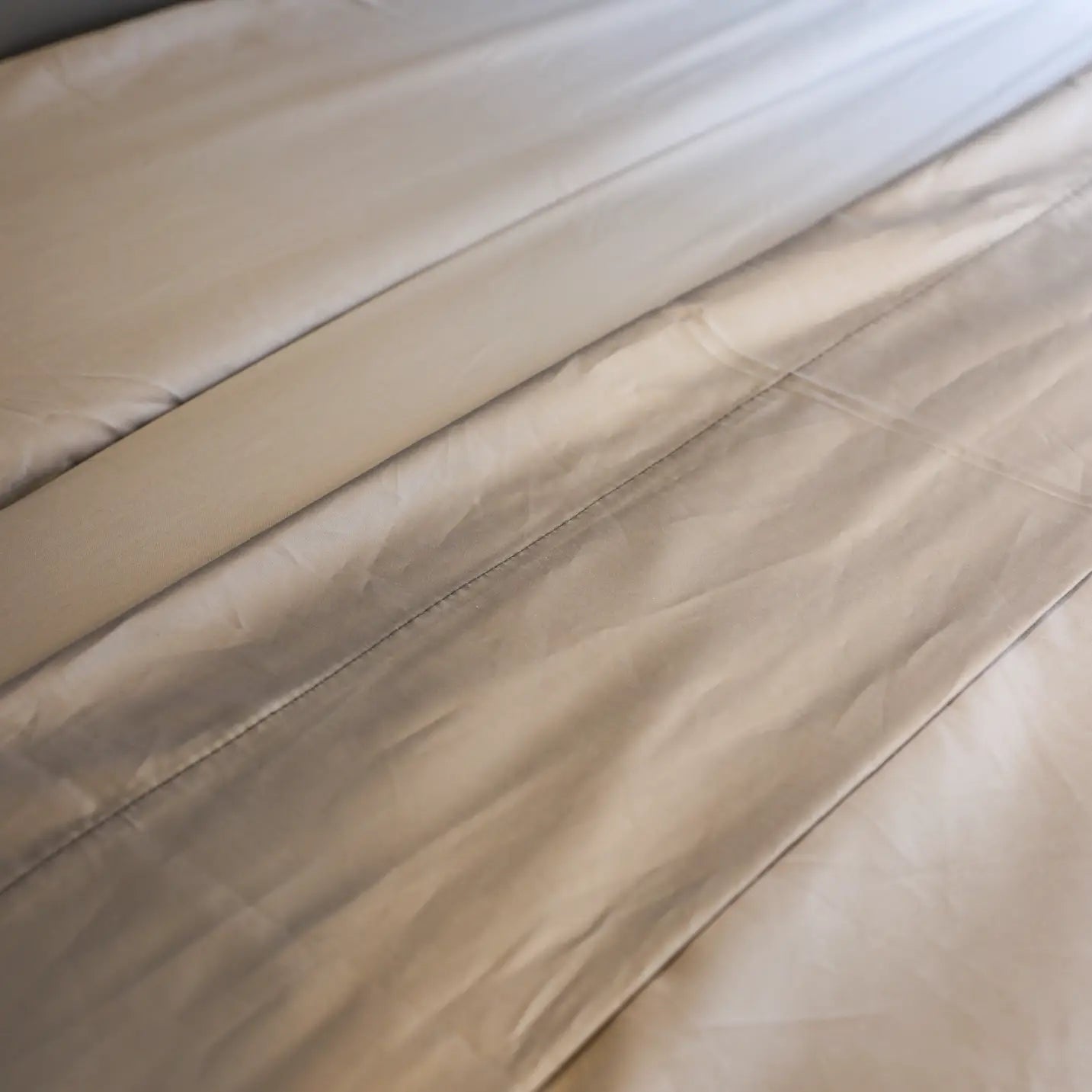 Close-up of soft beige Dream Bundle sheet set on a van mattress surface