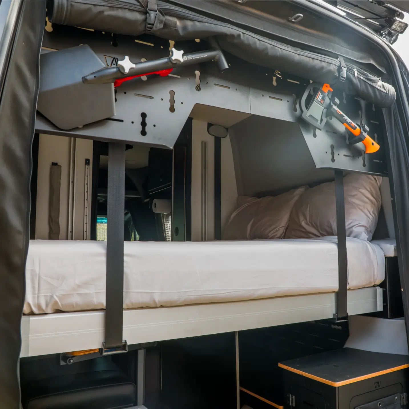 Revel van interior showing raised bed with storage shelf and mounted tools