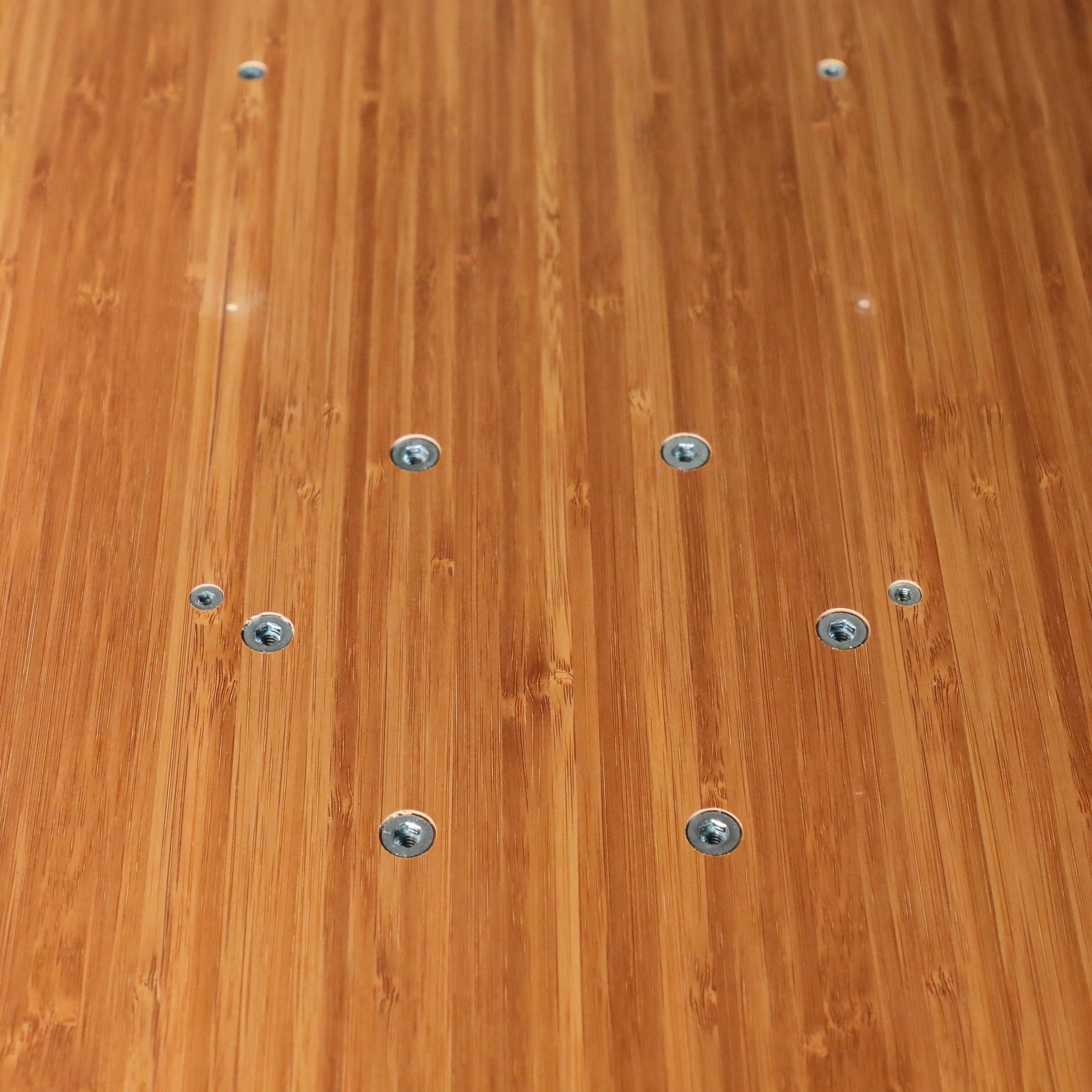 Close-up of the Solo Folding Table Top with visible screws on a bamboo wood surface