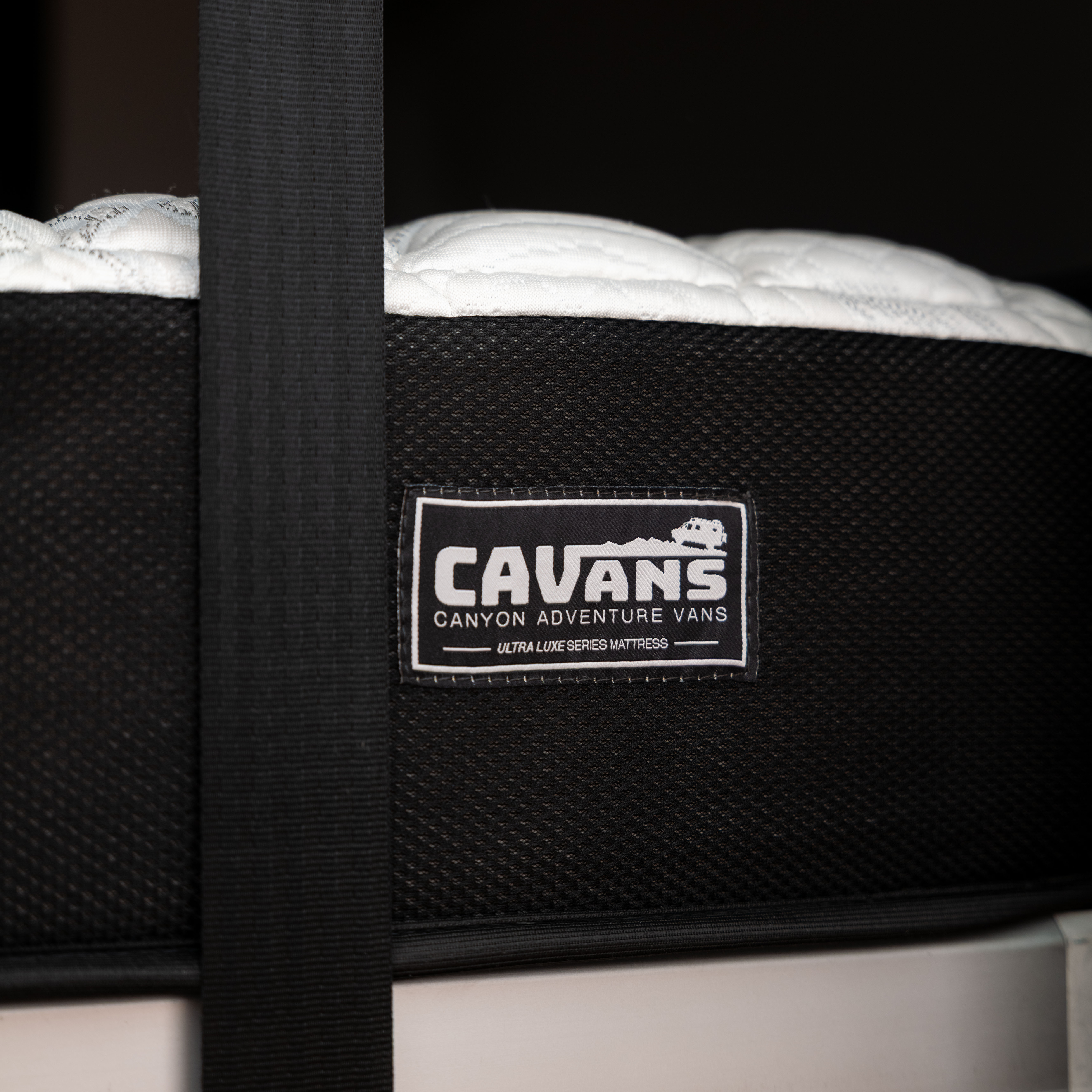 Close-up of CAVANS Ultra Luxe Series mattress label on a van bed.